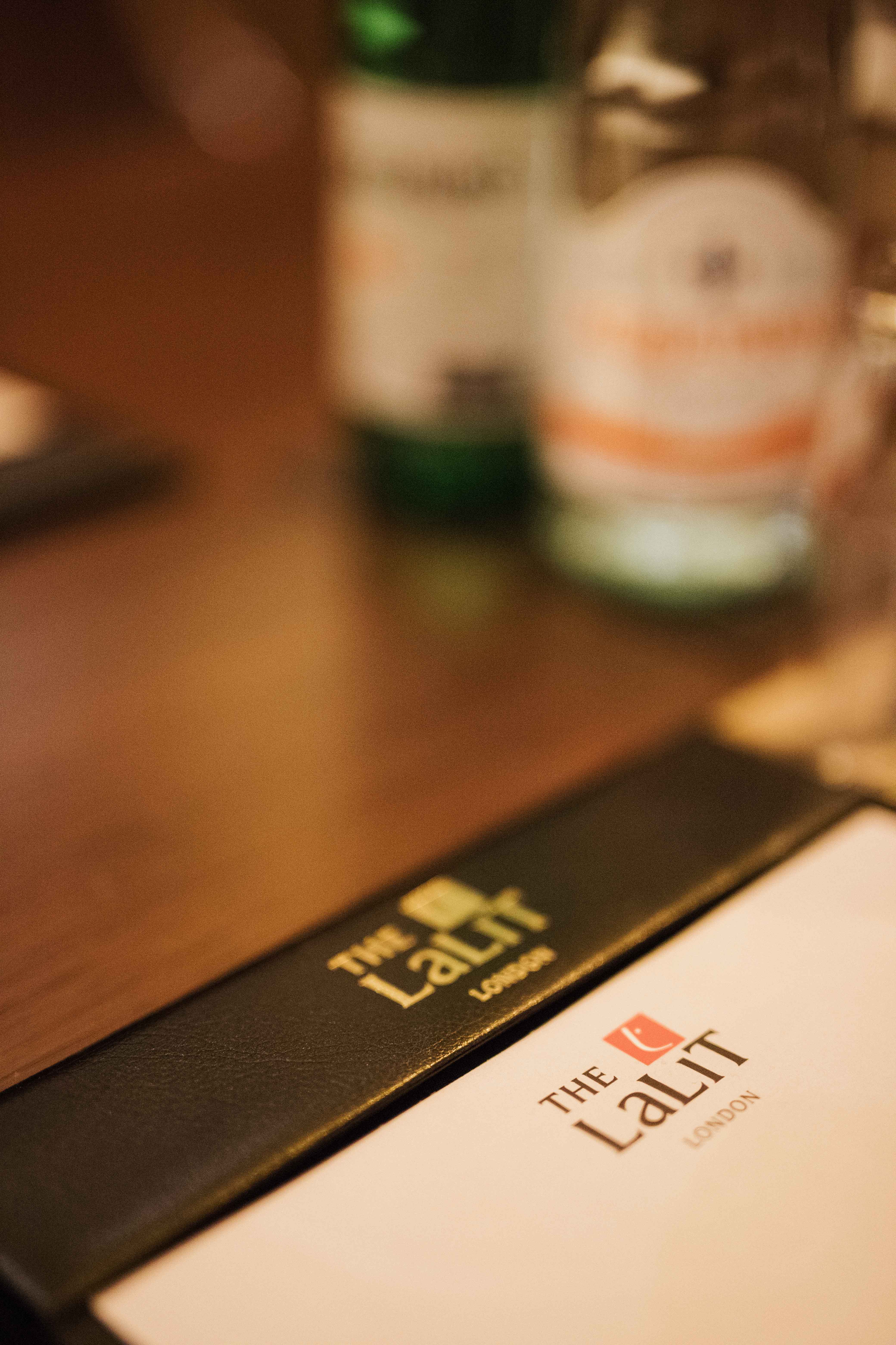 Meeting table setup in Laboratory 2, The LaLiT London, with branded notebook and water bottles.