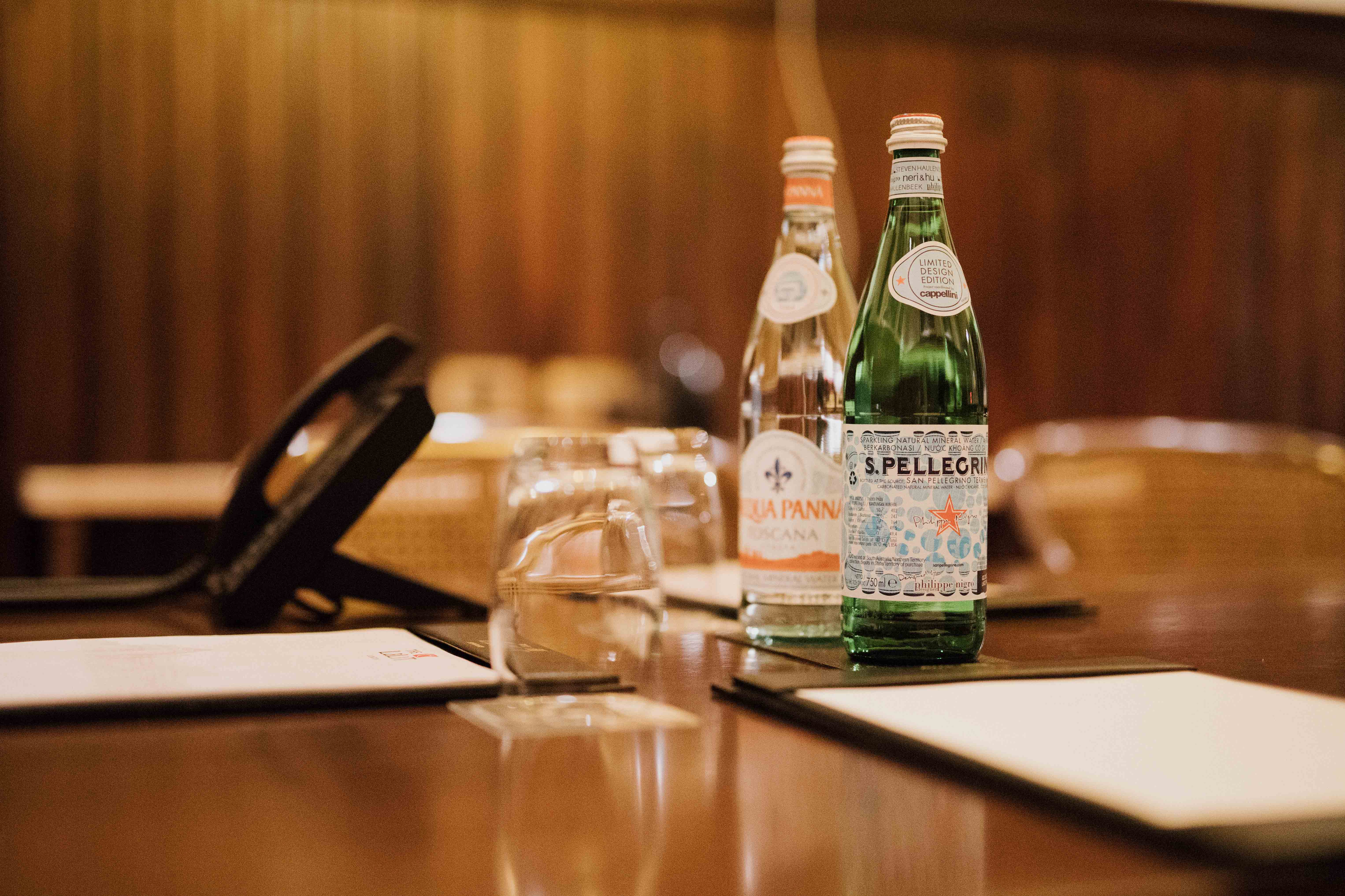 Elegant meeting setup in Laboratory 2, The LaLiT London with premium bottled water.