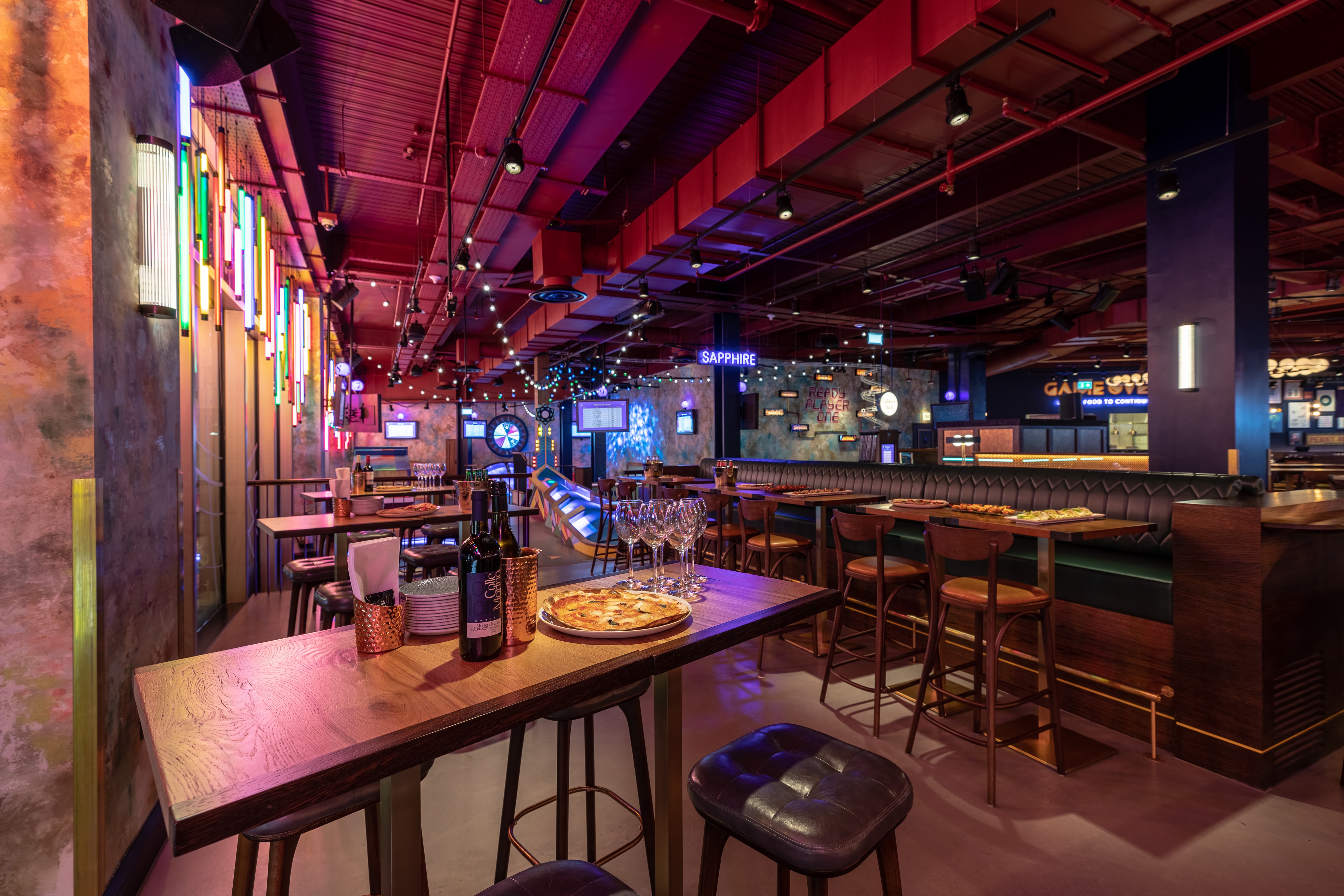 Vibrant event space with neon lights at Puttshack White City for networking and gatherings.