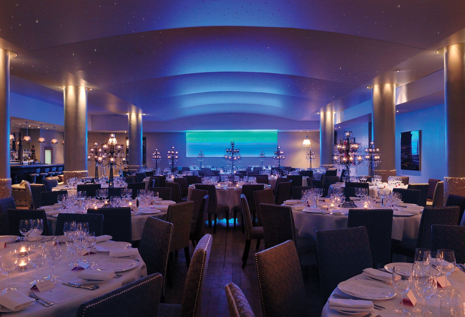 Sophisticated dining space with blue lighting for upscale events at Haymarket Hotel.