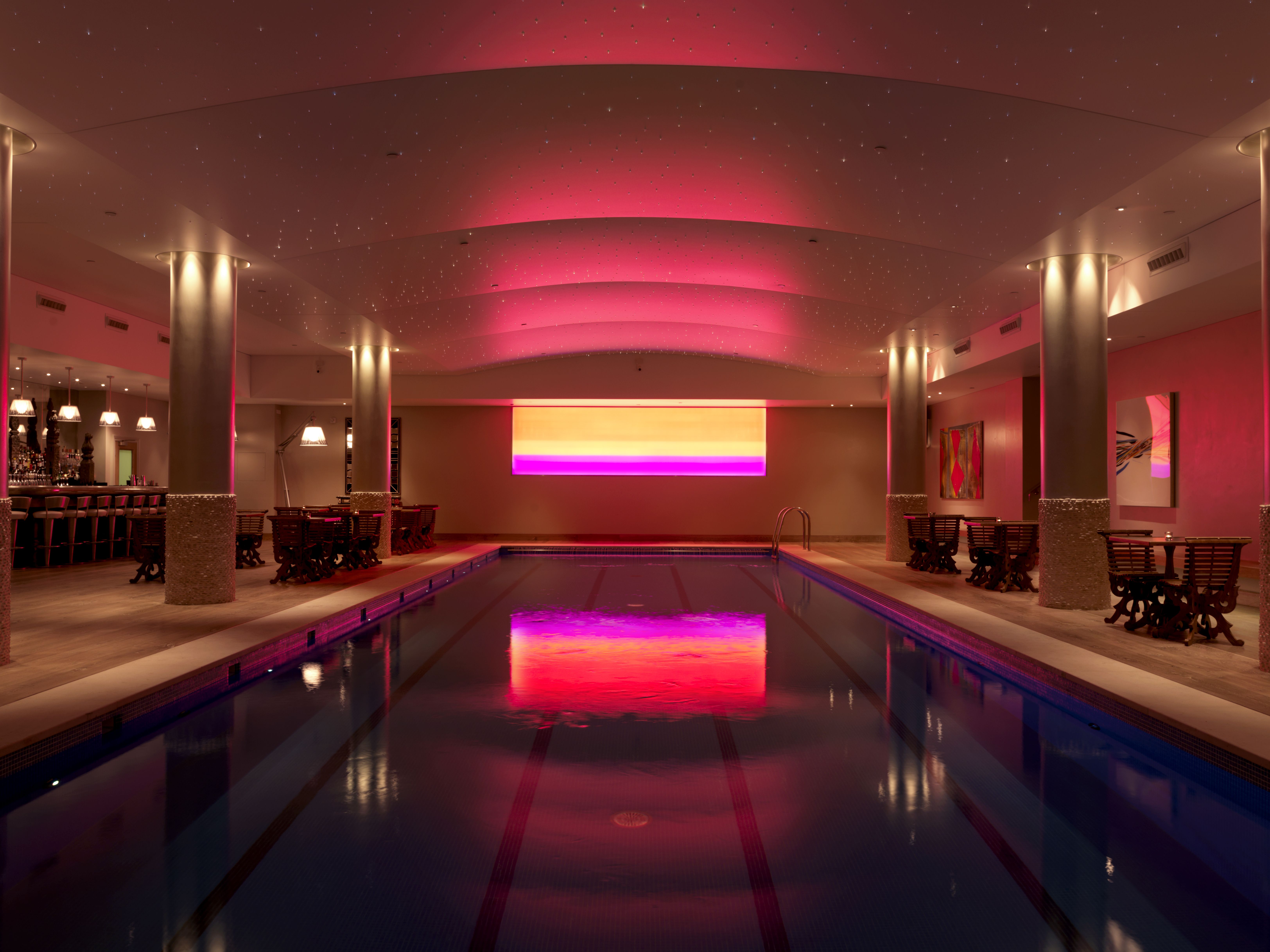 Indoor pool area at Haymarket Hotel, elegantly lit for exclusive events and gatherings.