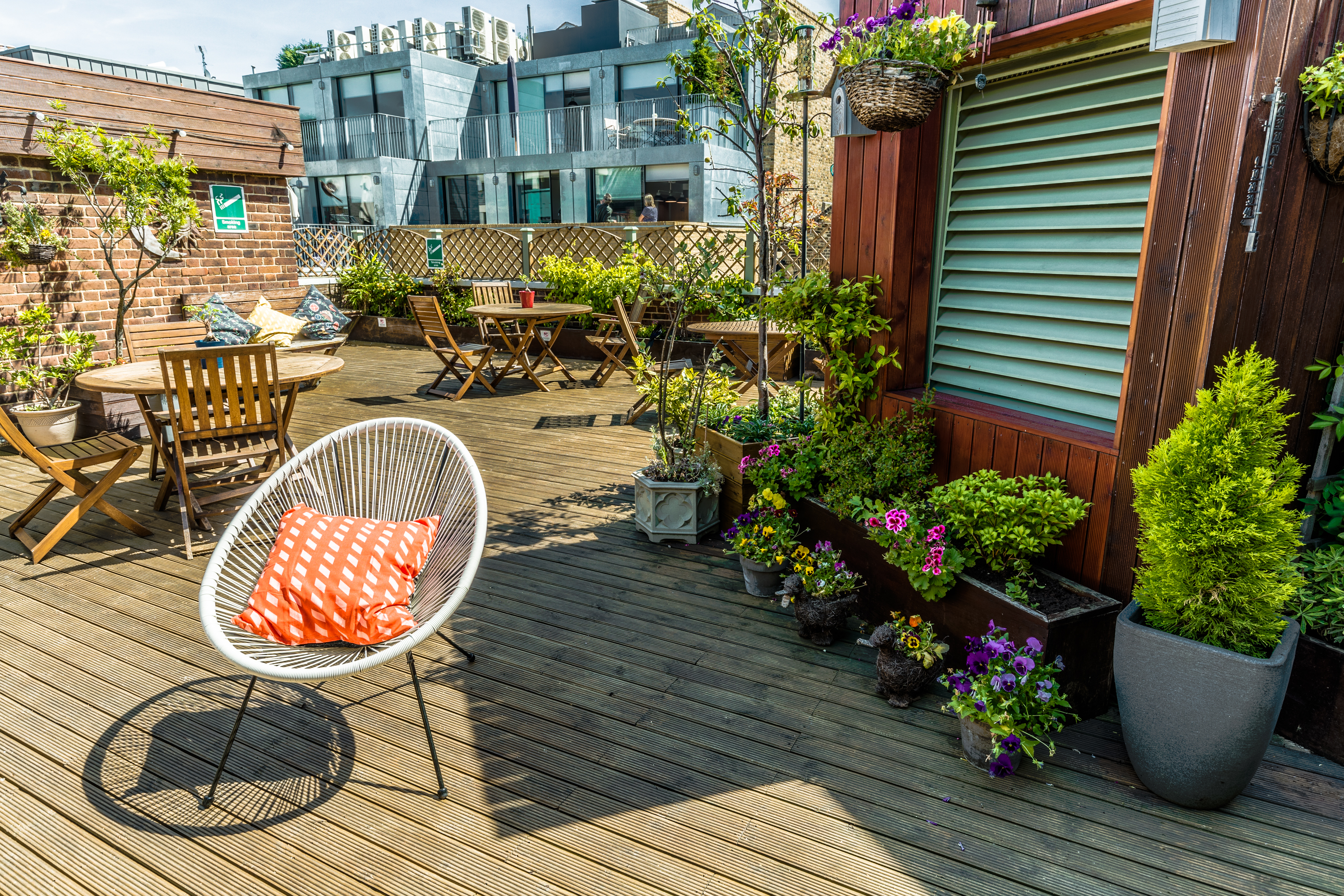 Vibrant rooftop venue with wooden deck for casual meetings and networking events.