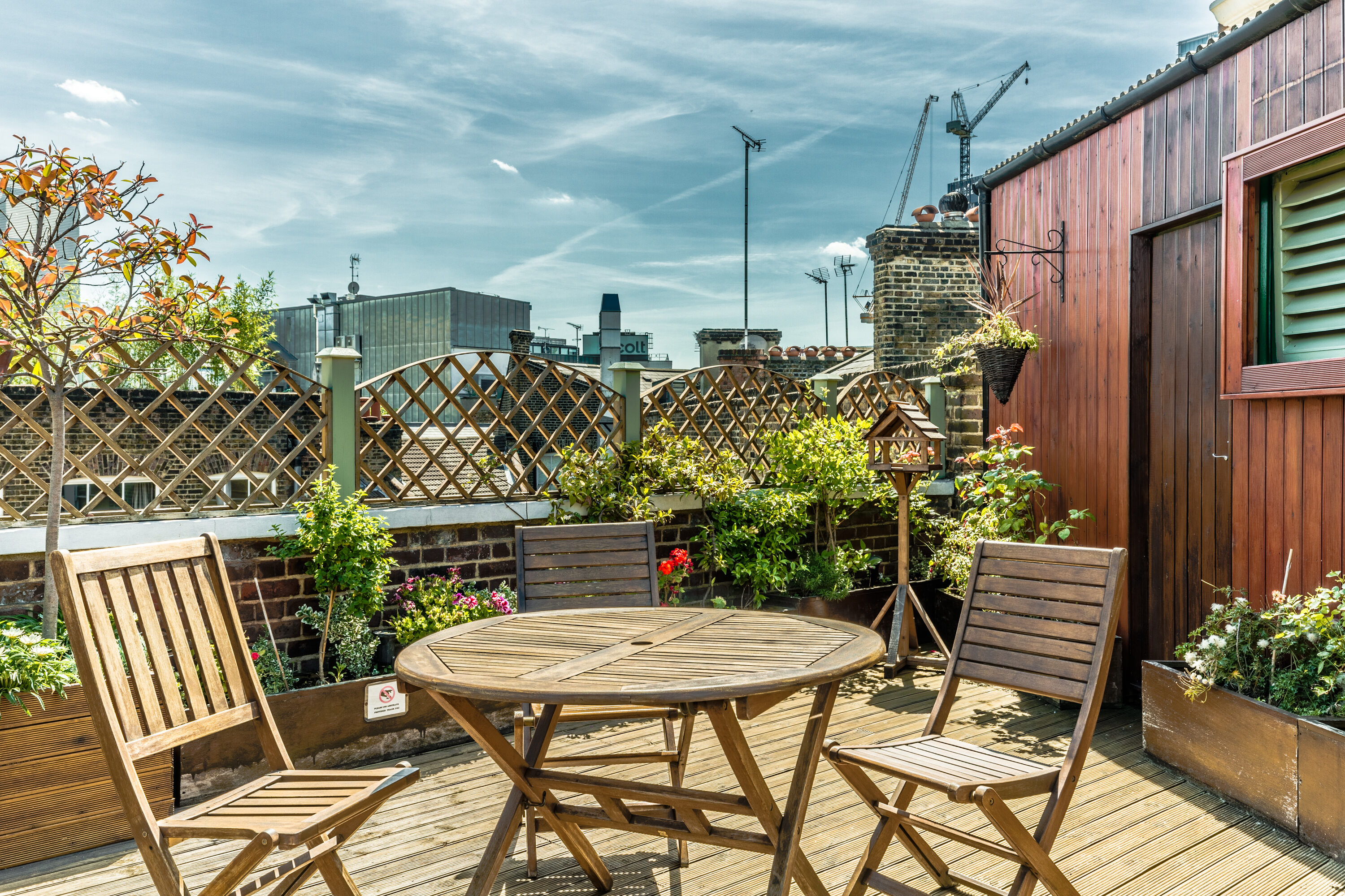 Charming rooftop venue with wooden furniture, ideal for gatherings and networking events.