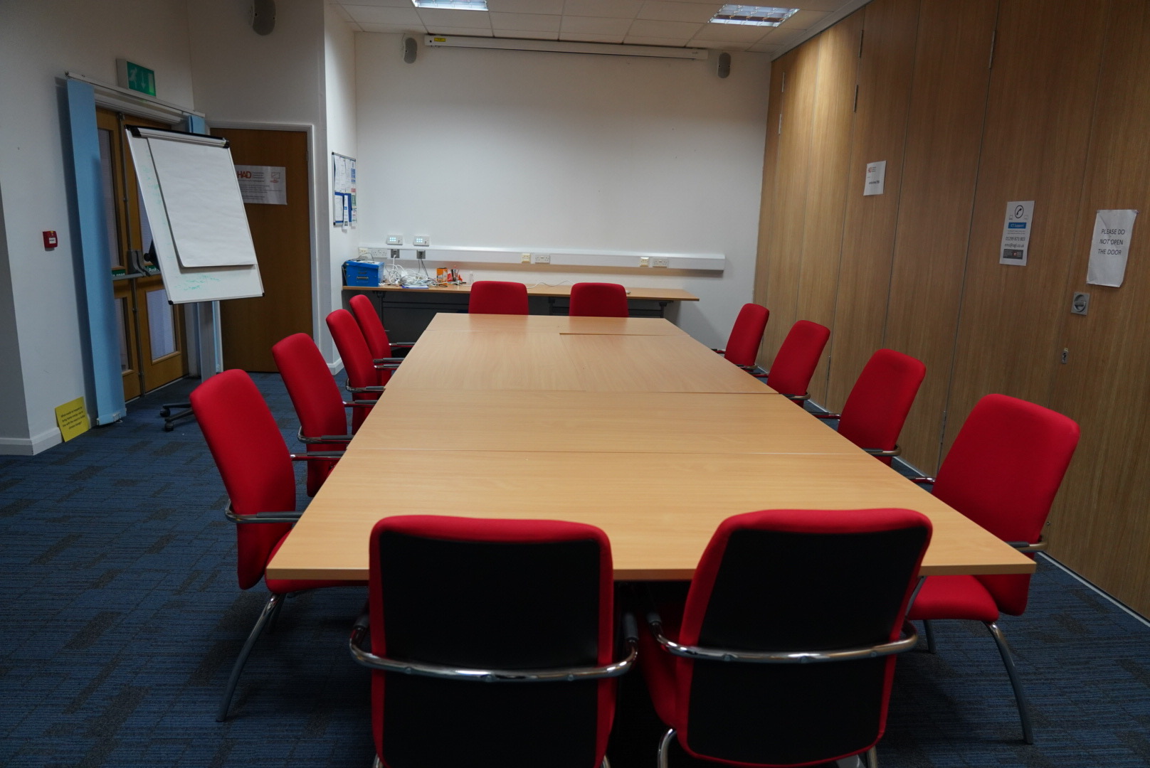 Meeting Room 1 at HAD with a large table and red chairs, perfect for corporate workshops.