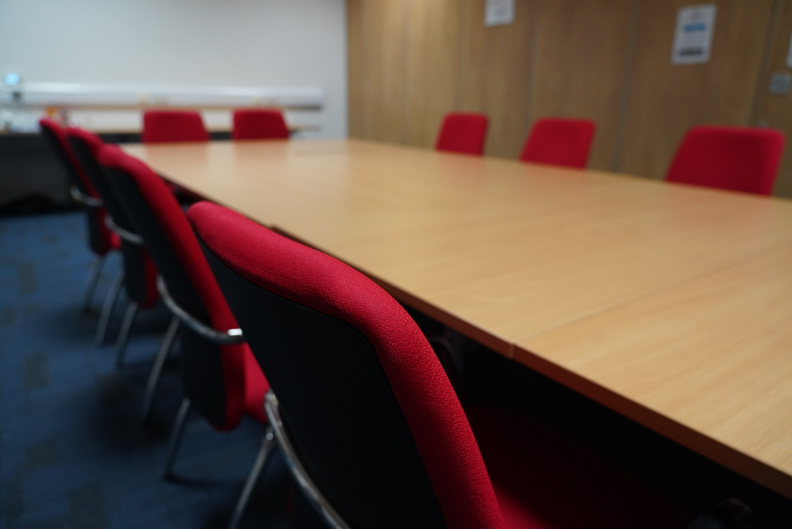 Modern meeting room with wooden table and red chairs at Humanitarian Academy for Development.