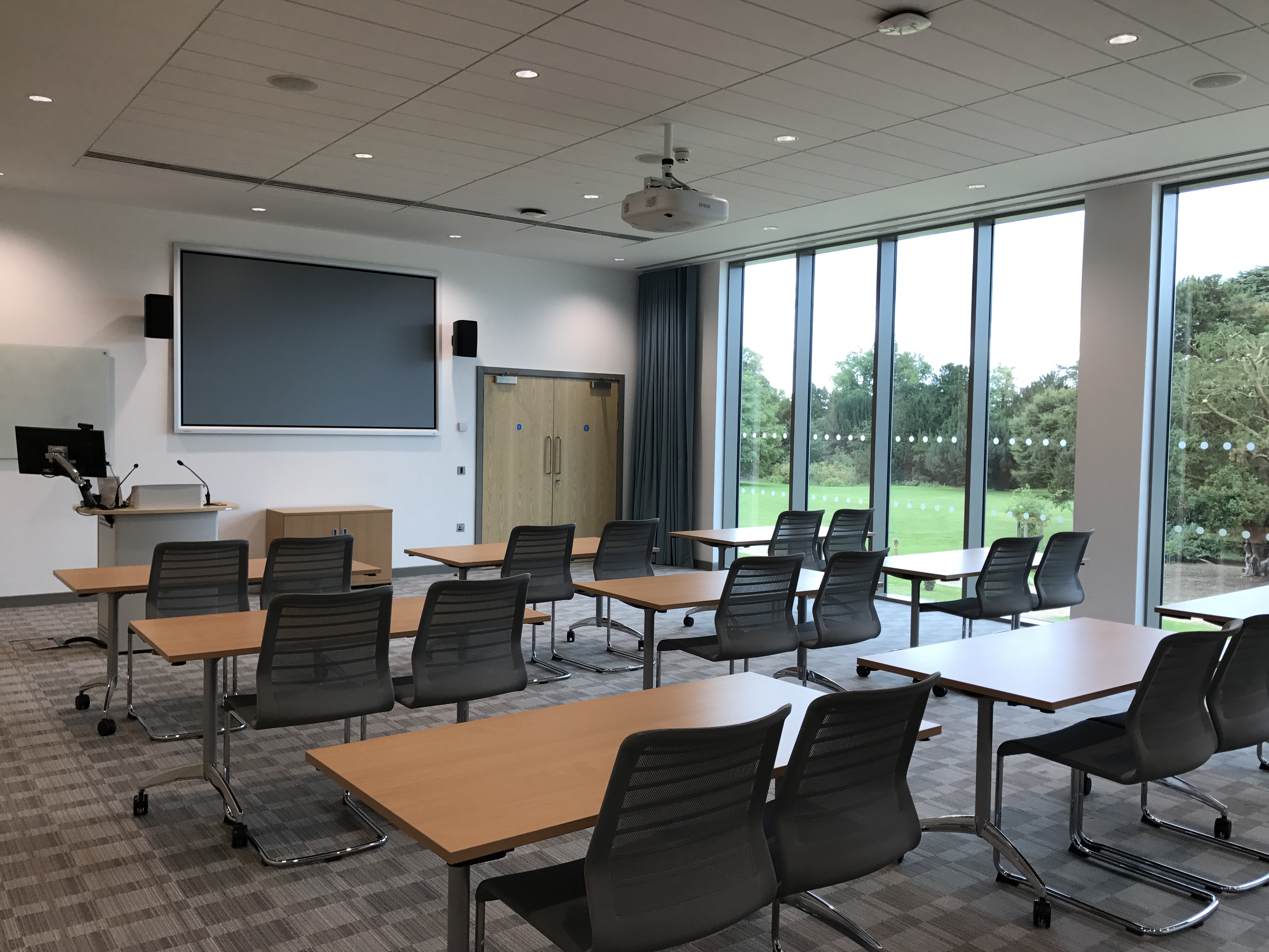 Well-lit meeting room with modular tables, ideal for workshops and seminars.