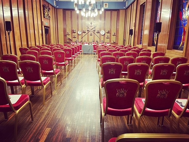 Elegant red chairs in The Livery Hall, perfect for conferences and seminars.