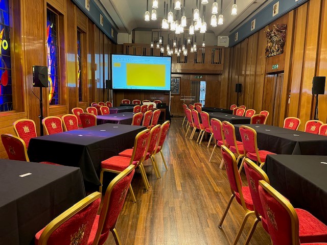 Livery Hall meeting space with black tables, red chairs for corporate events and presentations.
