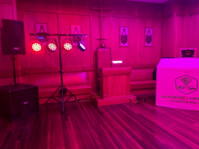 Vibrant event space in Bakers' Hall with wooden backdrop, ideal for presentations and gatherings.