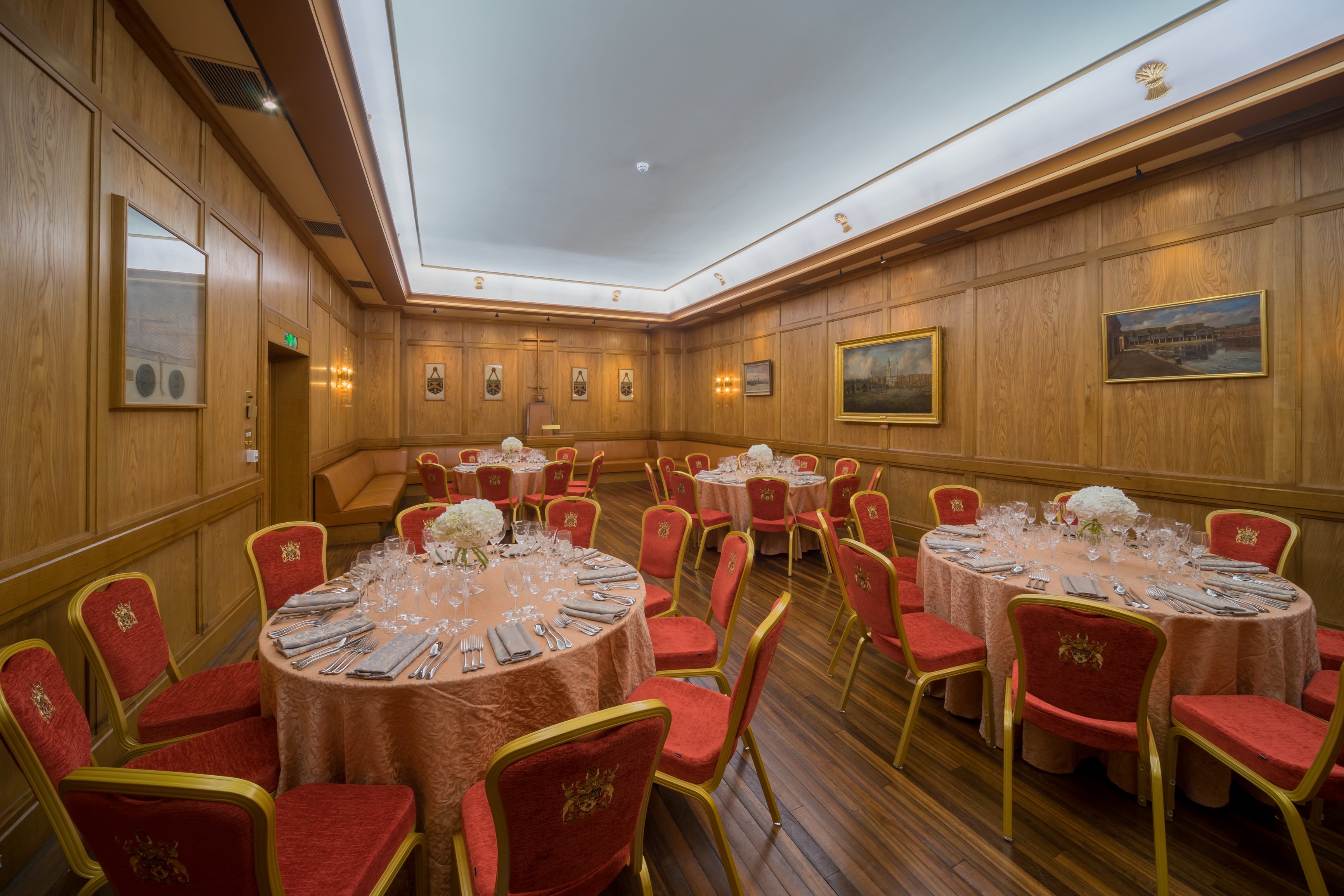 Elegant event space in Bakers' Hall with floral centerpieces, perfect for corporate gatherings.