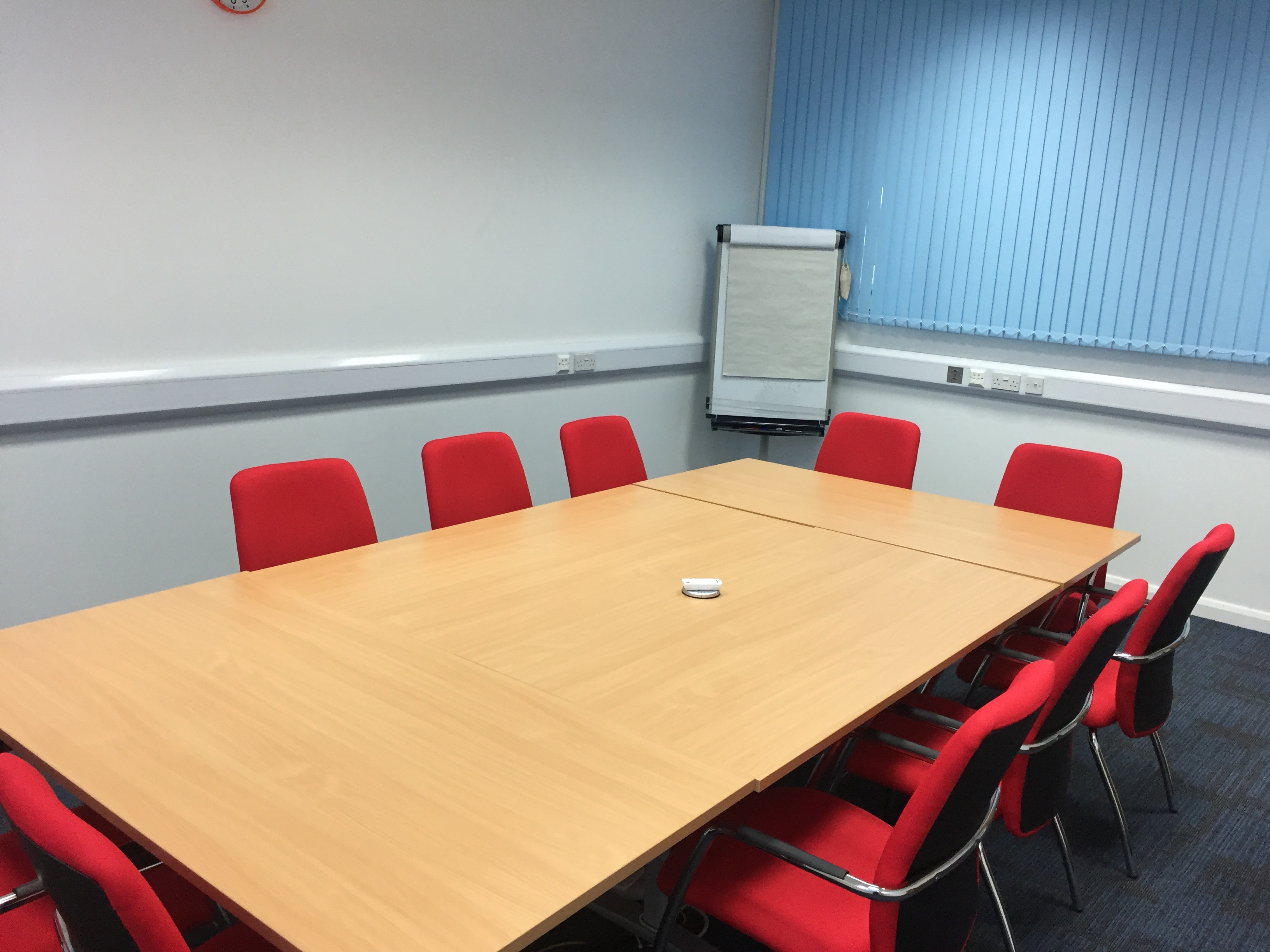 Meeting Room 4 at HAD with a large table, red chairs, ideal for collaborative events.