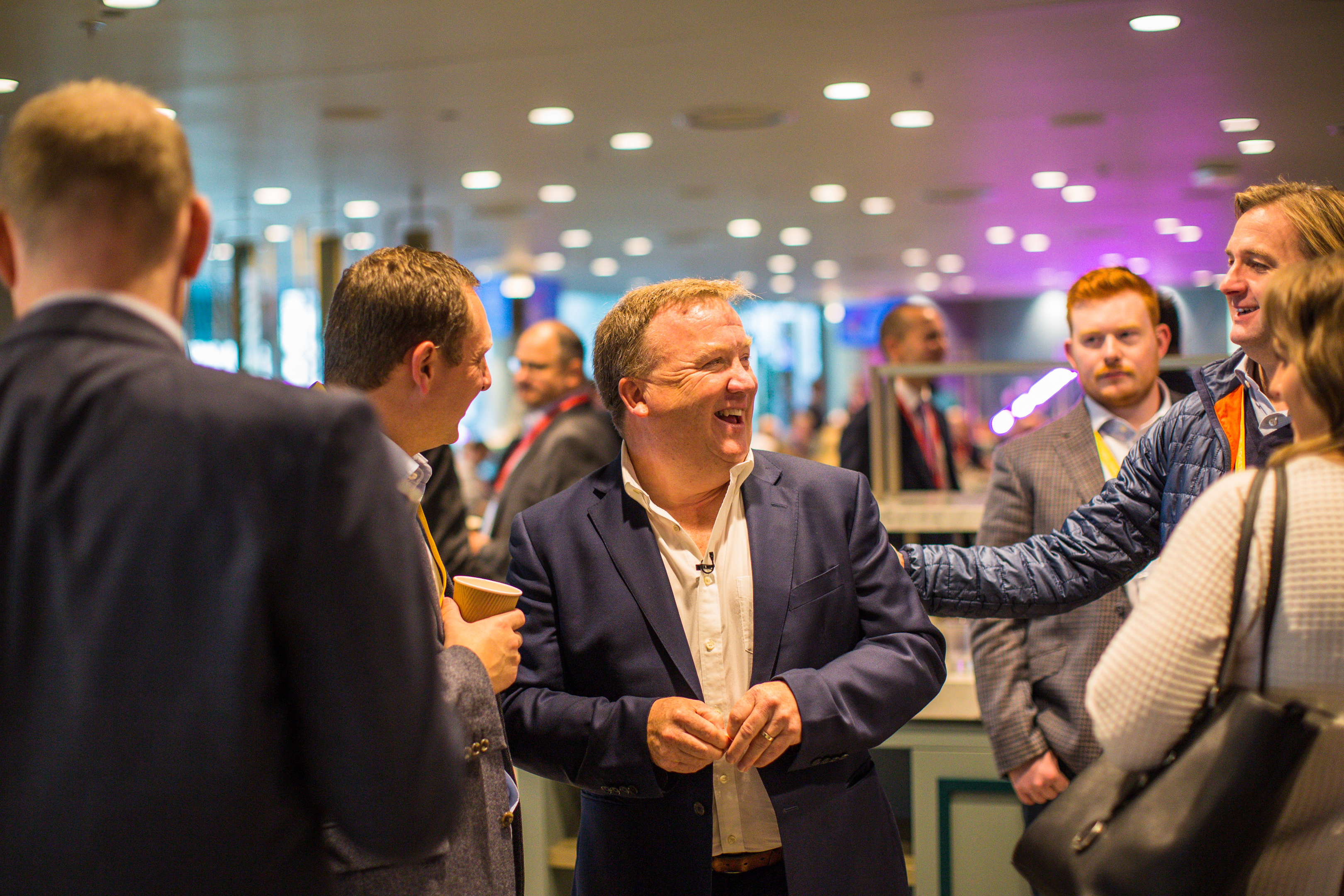 Vibrant networking event in The Atrium, Wembley Stadium with engaged attendees.