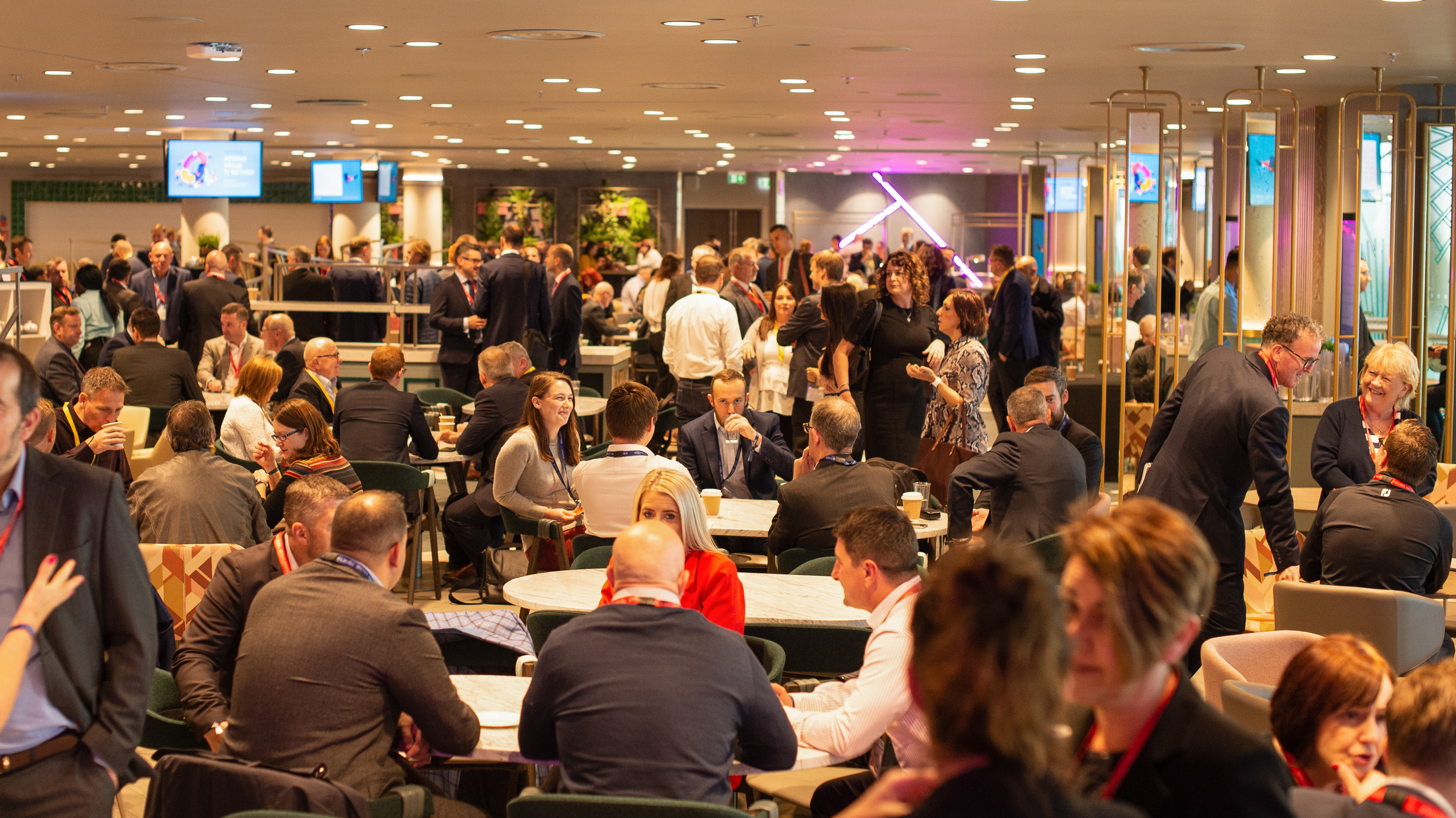 Networking event in The Atrium, Wembley Stadium with vibrant atmosphere and greenery.