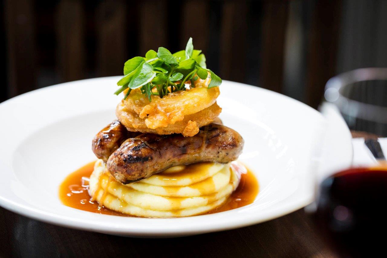Irish Whisky Vault dish: sausages on creamy mash, perfect for upscale events and catering.