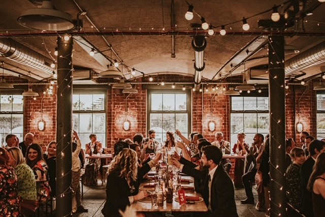 Vibrant event space with rustic walls, ideal for weddings and corporate gatherings.