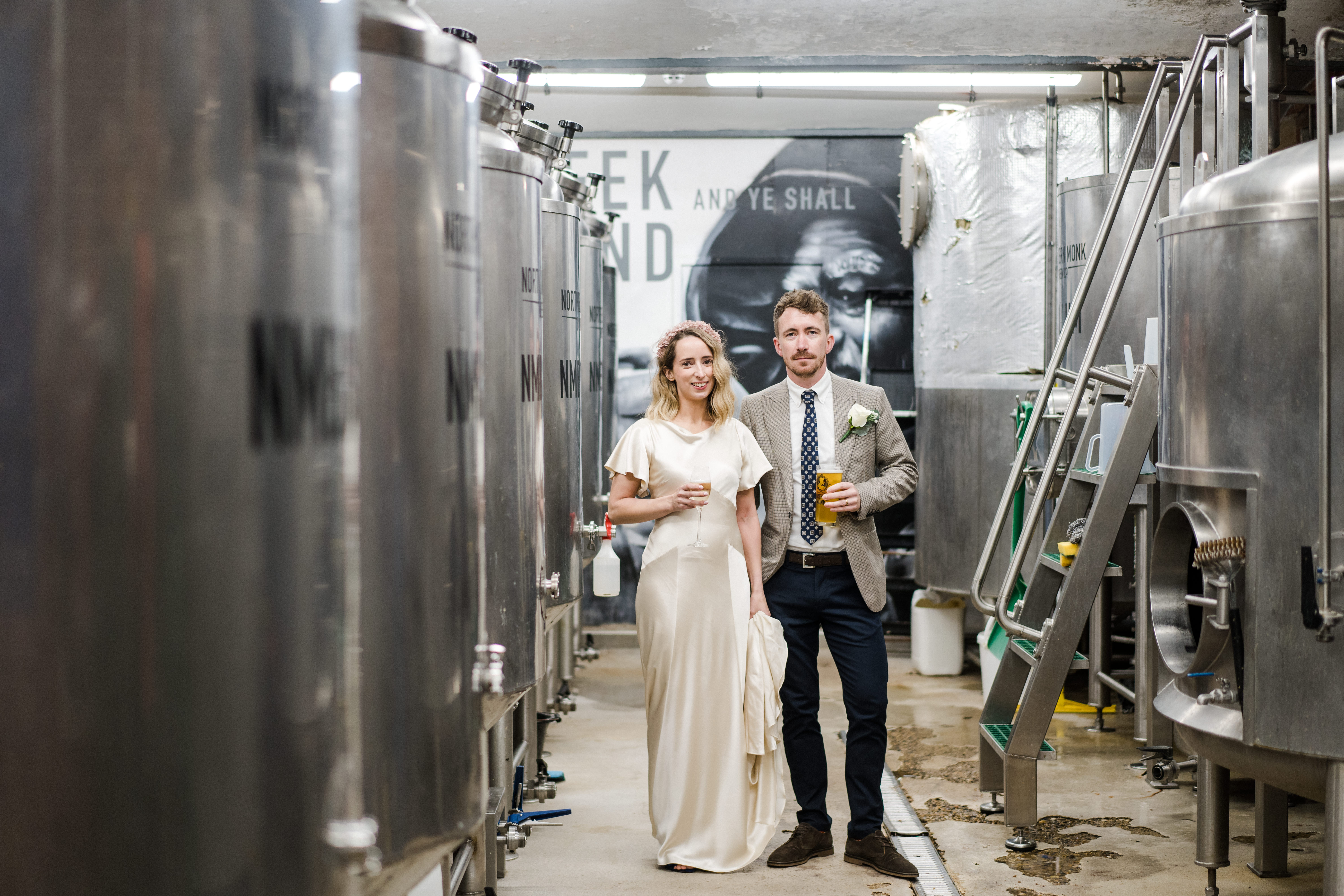 Couple in formal attire at a unique brewery venue for creative events.