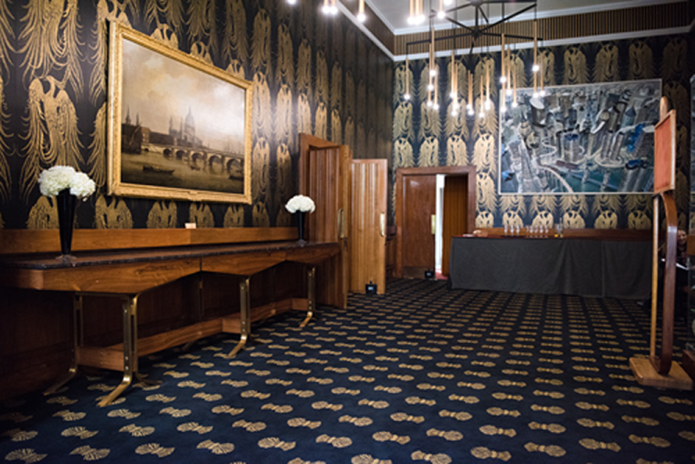 Elegant event space at The Charter Gallery, featuring rich wallpaper and chandeliers.