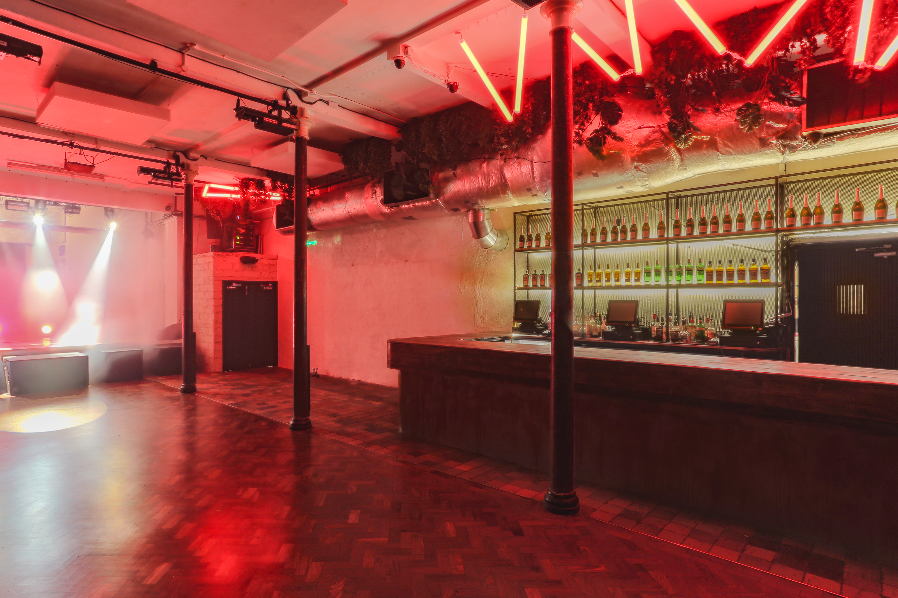 Versatile event space at 93 Feet East with sleek bar and vibrant lighting for gatherings.
