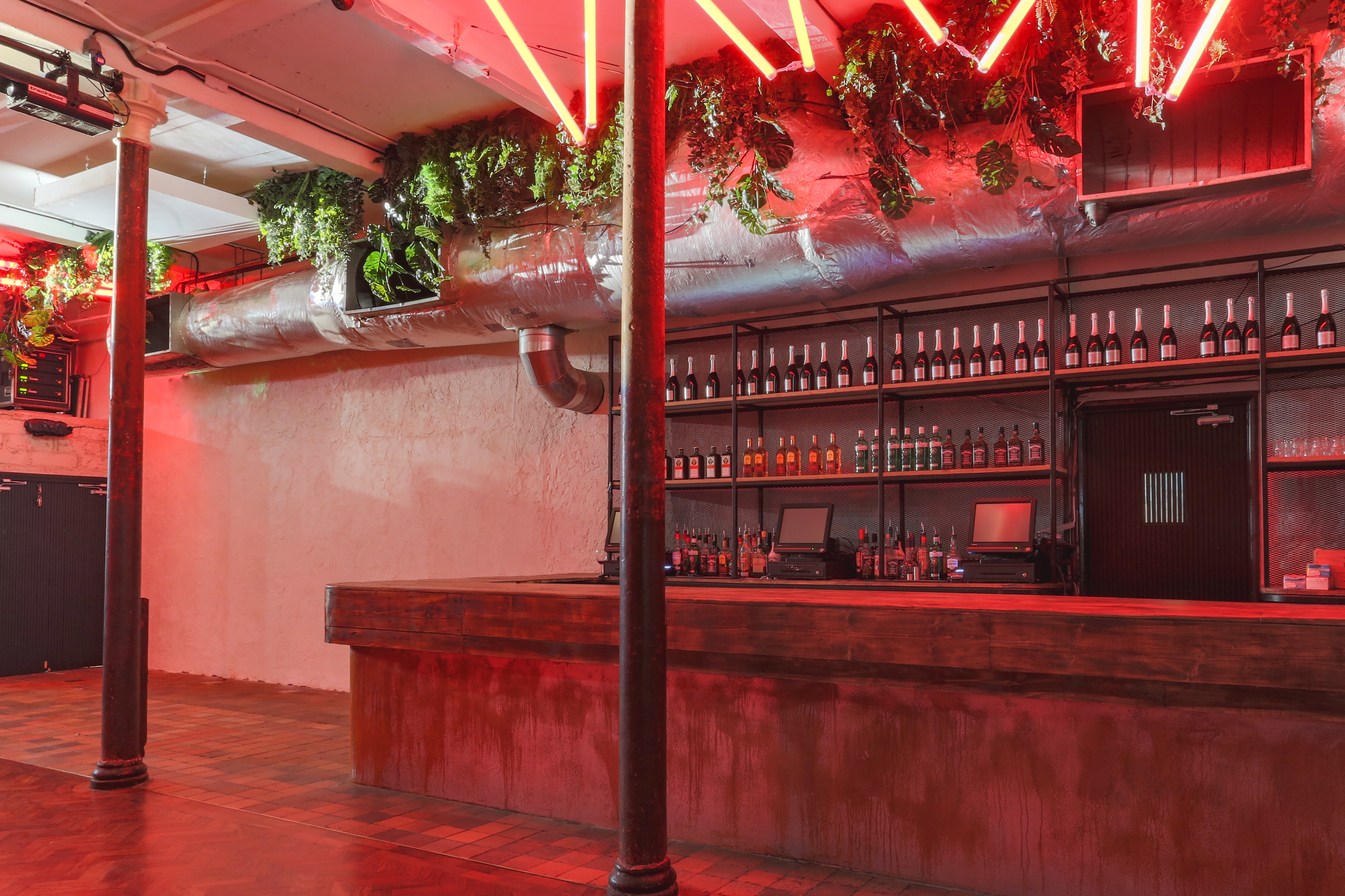 Stylish bar at 93 Feet East, featuring neon lights and greenery for events.