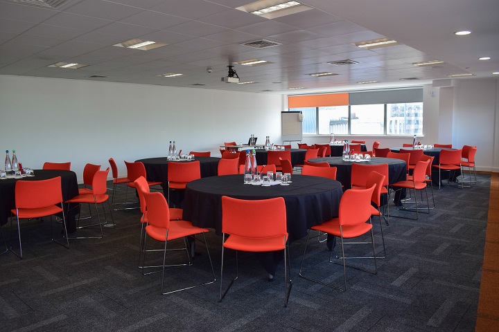 Modern event space in Glasgow with round tables, ideal for workshops and networking.