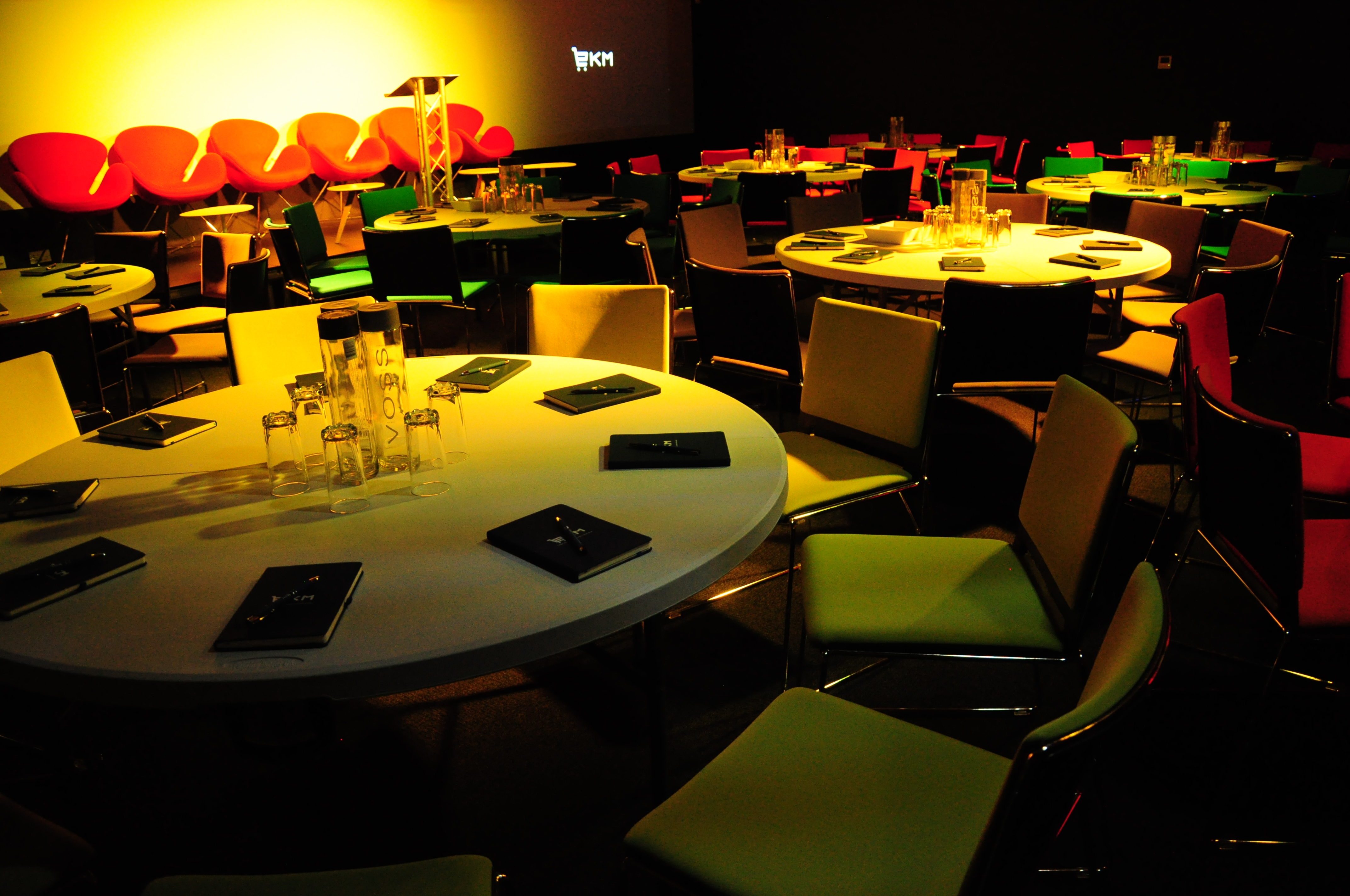 Auditorium in EKM with round tables set for a vibrant conference meeting.