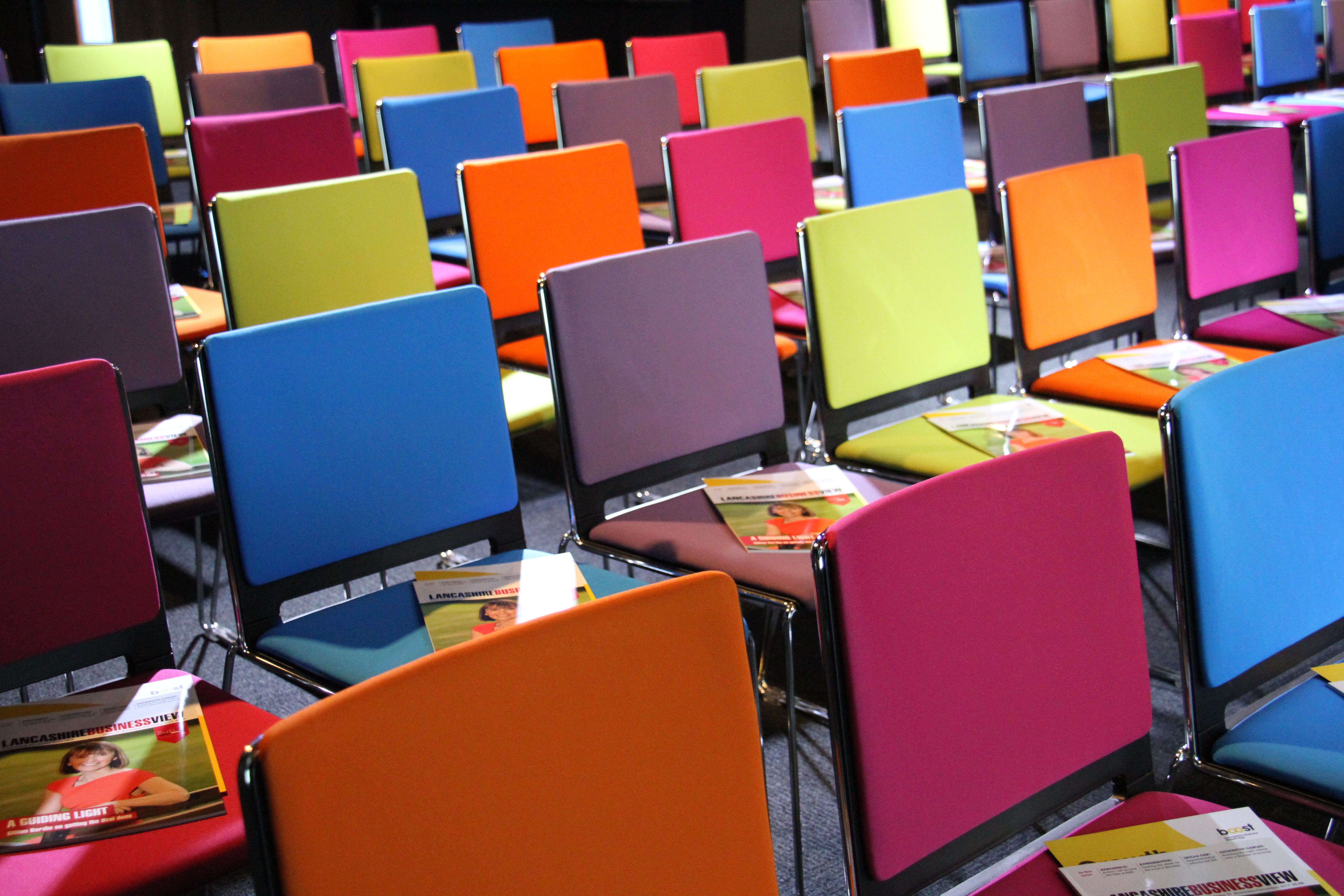 Colorful chairs arranged in EKM auditorium for an engaging event or workshop.