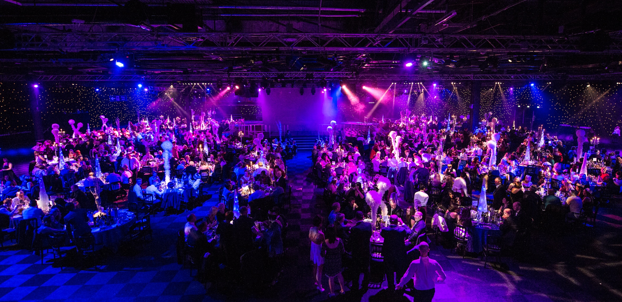 "Hall 4 at EventCity: Vibrant gala space with elegant tables and dynamic lighting."