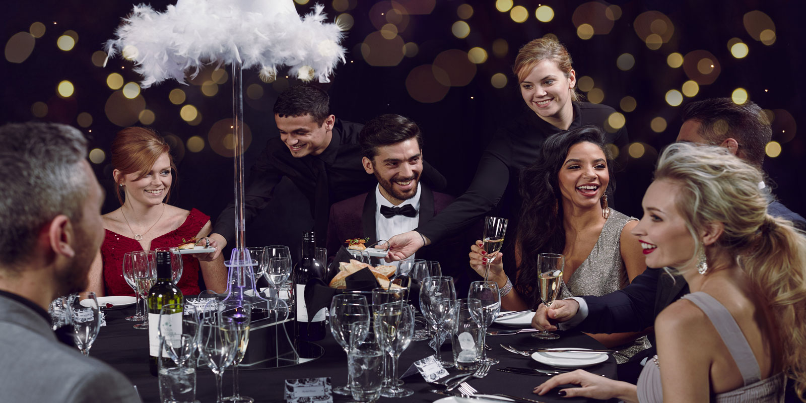 Elegant banquet table with feather centerpiece at EventCity gala, showcasing vibrant atmosphere.
