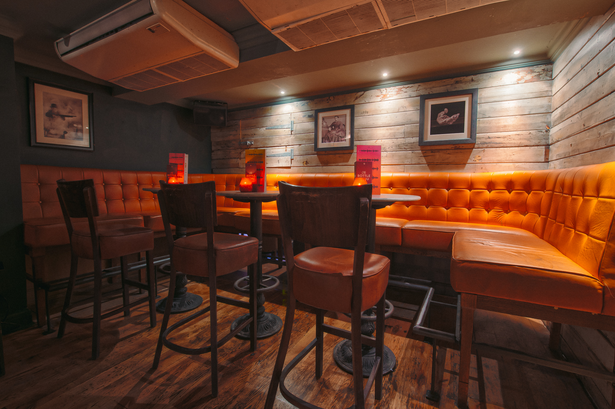 Stylish seating area with orange banquette for networking events in Revolution Brighton.