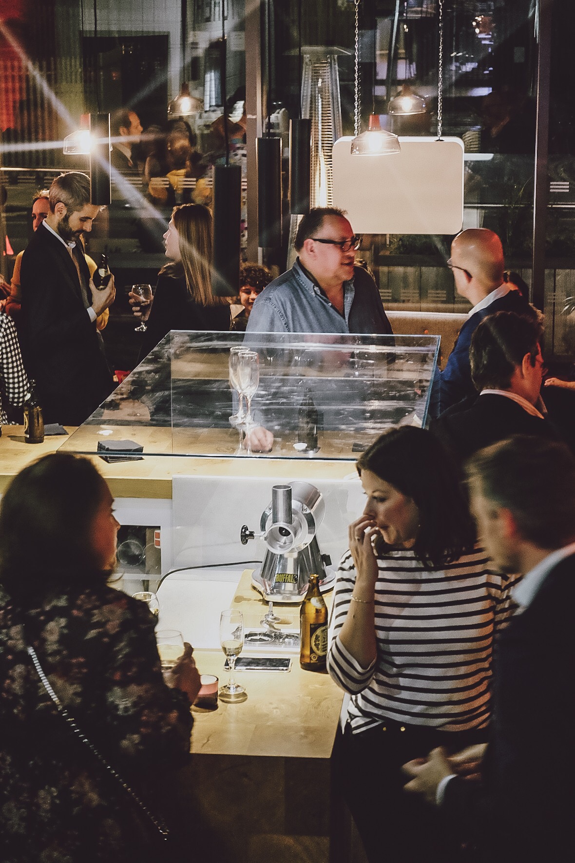Vibrant networking event at Cut and Grind with sleek display table and engaged attendees.