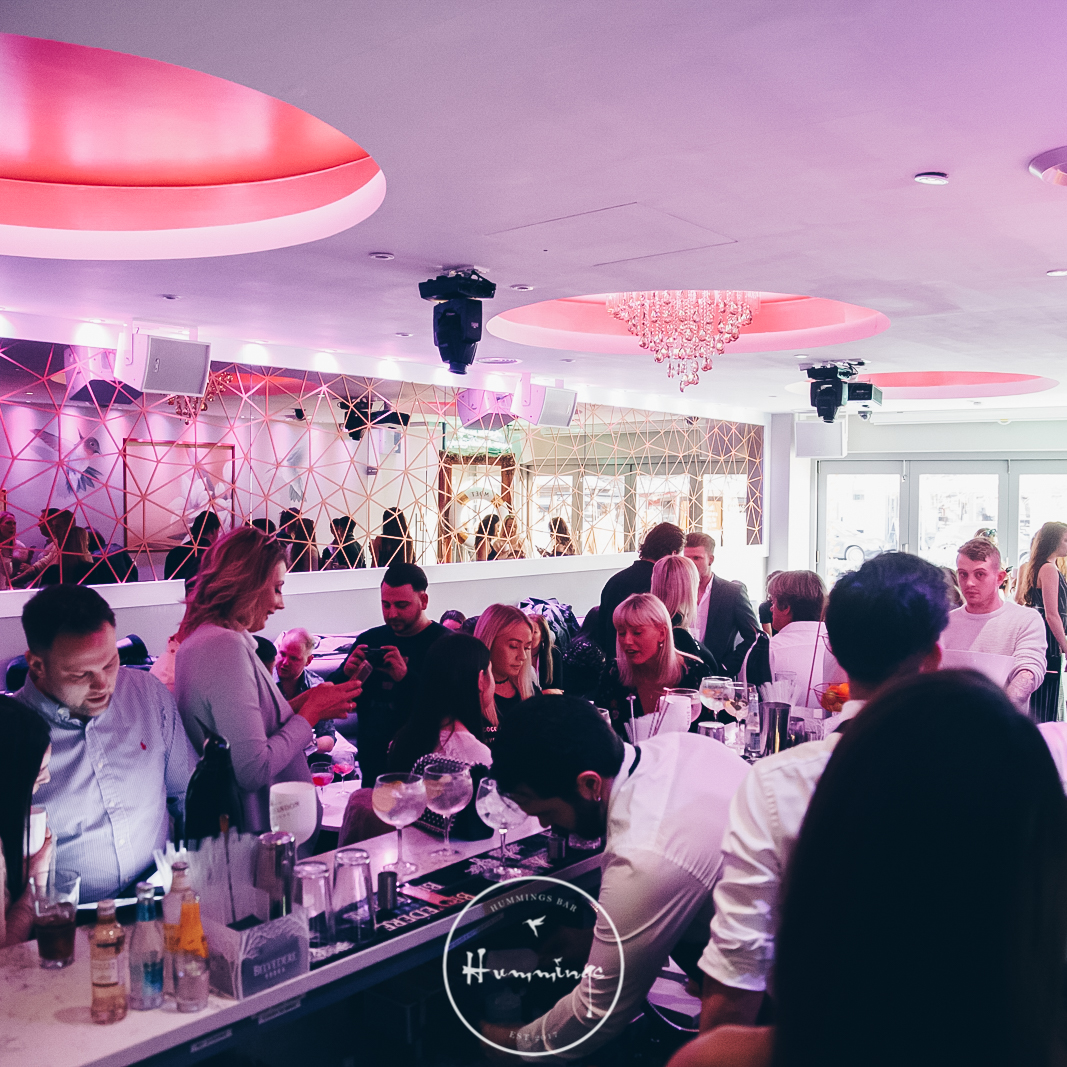 Vibrant event space with pink lighting, ideal for networking and social gatherings.