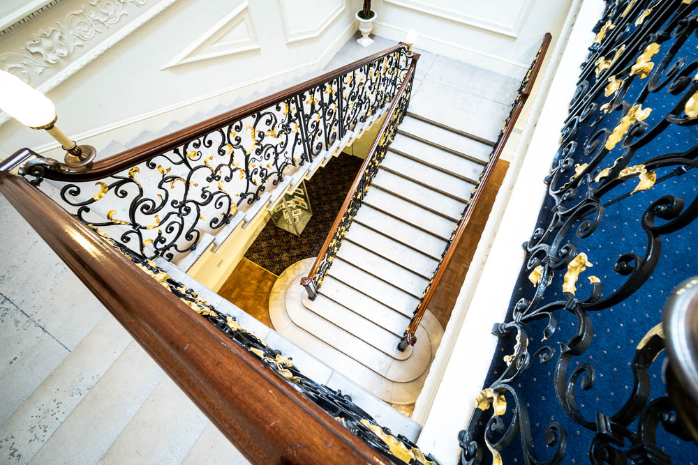 Elegant staircase with wrought iron railings at Weddings in Six Park Place, perfect for upscale events.