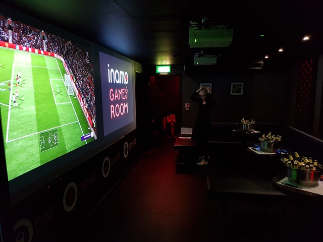Vibrant games room with large screen for engaging social events and team-building activities.