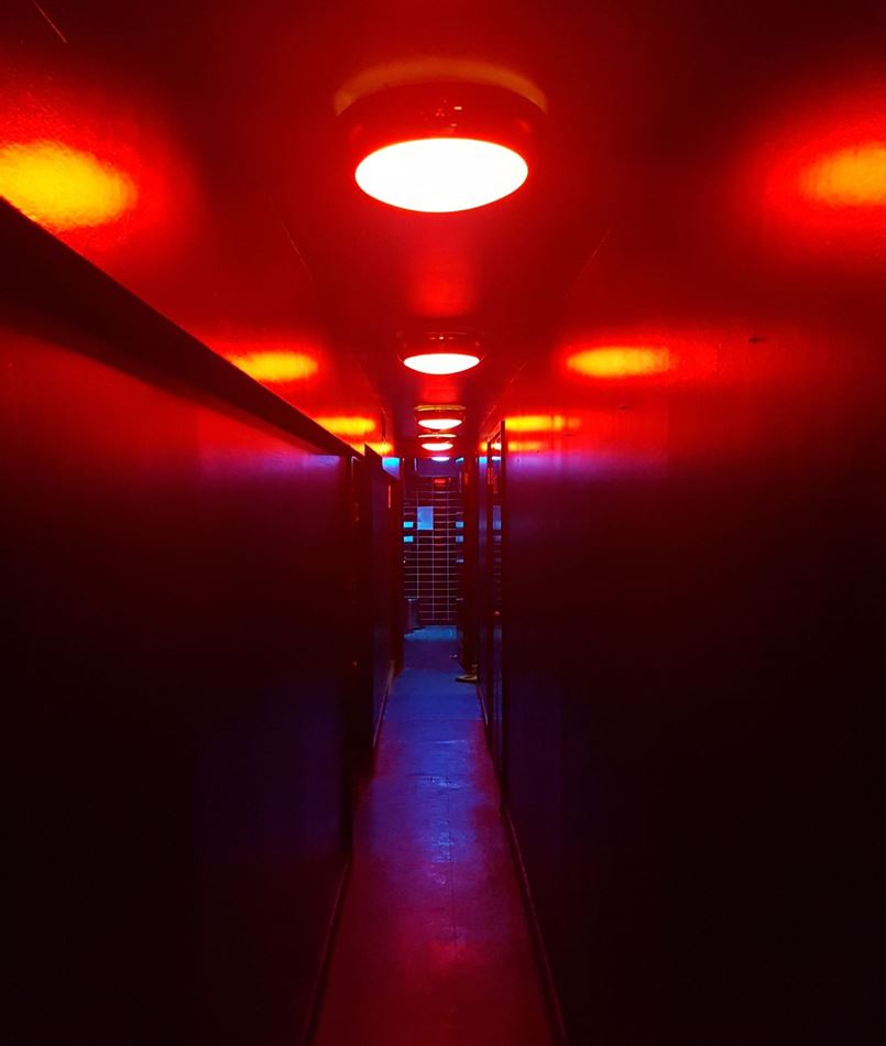 Dimly lit corridor with red lighting in The Games Room for themed events and immersive experiences.