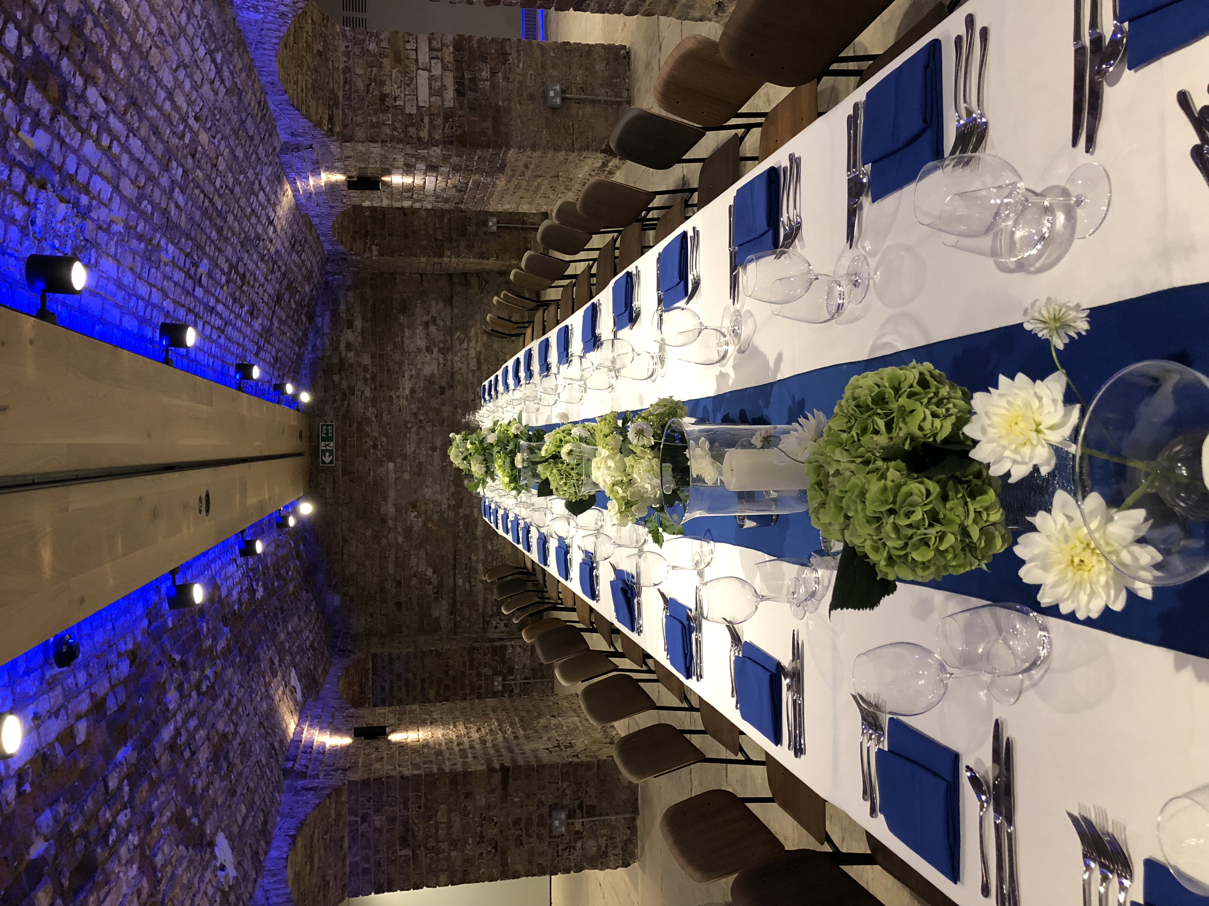 Elegant banquet table with white flowers at London Bridge Arches for corporate events.