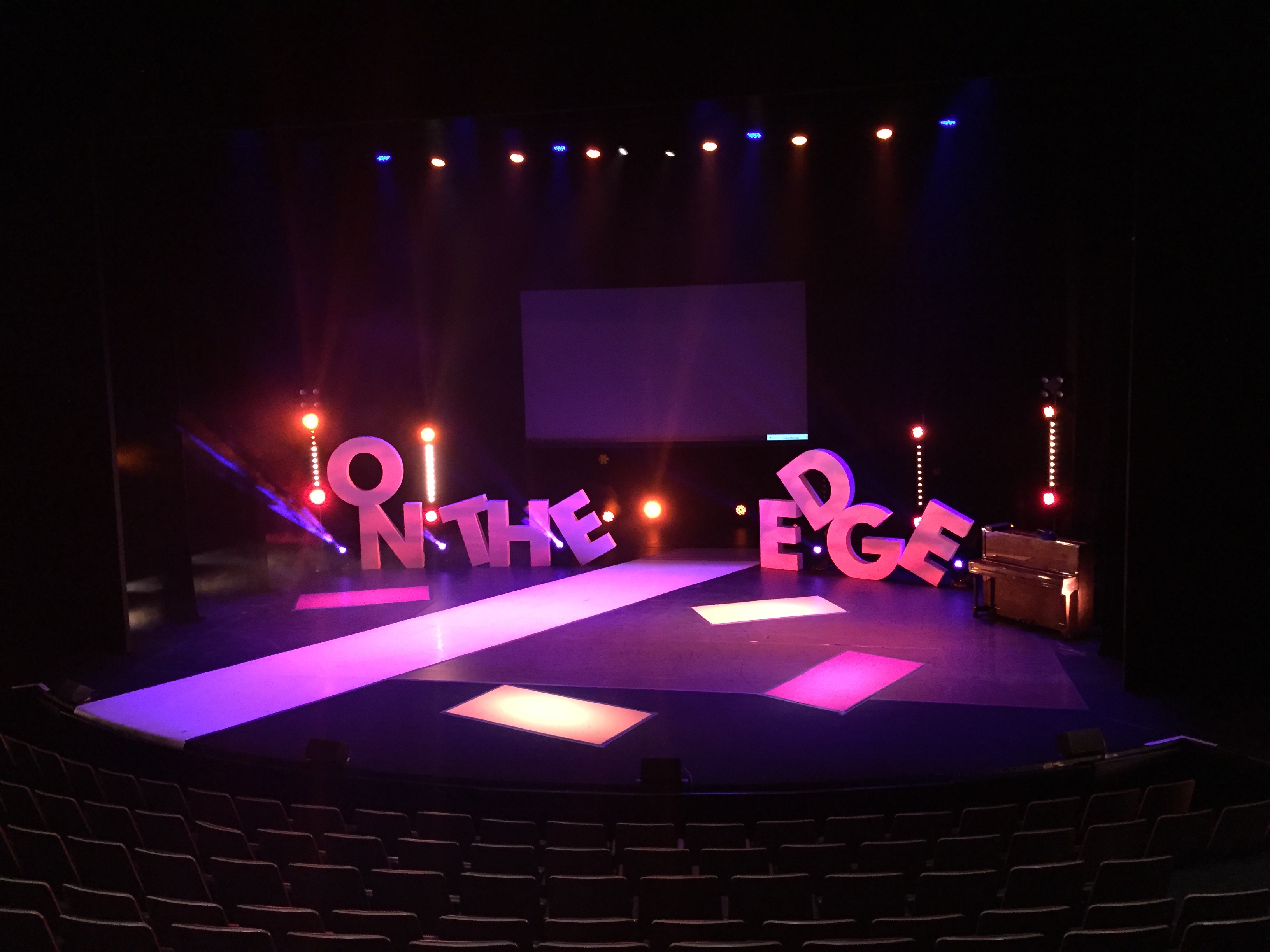 Dynamic stage setup with "ON THE EDGE" letters for engaging presentations in Birmingham.