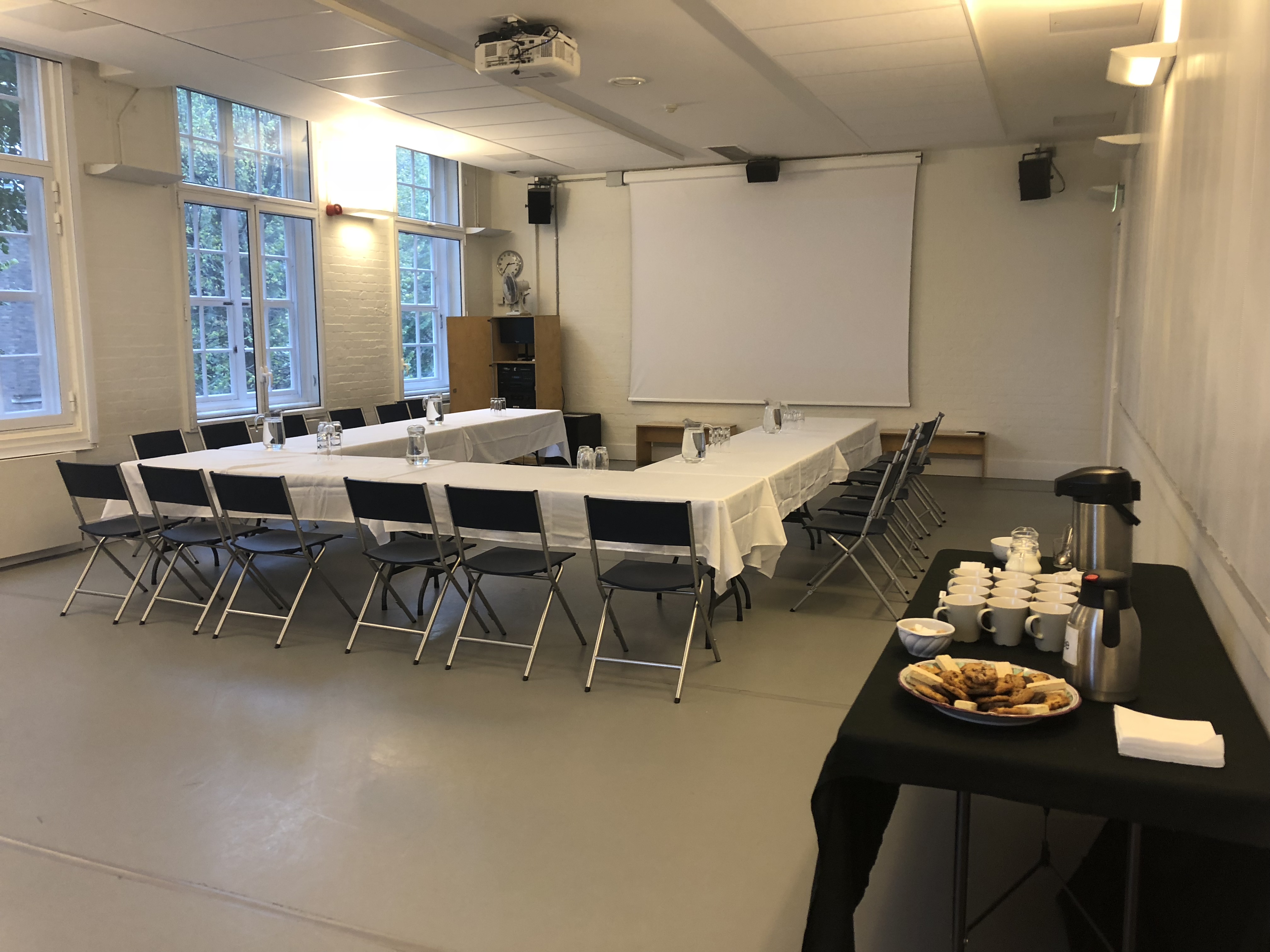 "Research Studio meeting space with large table, natural light, perfect for workshops or seminars."