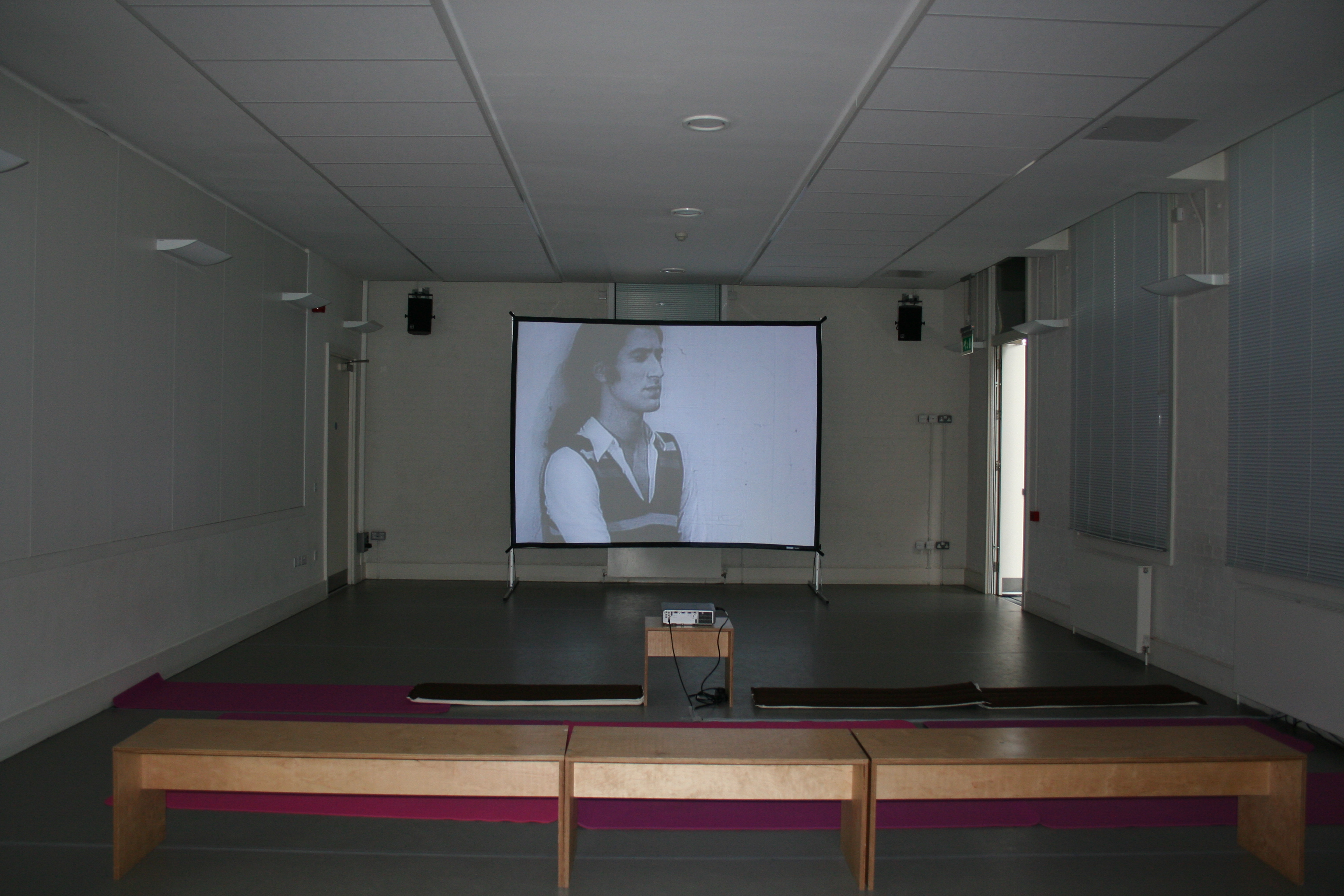 Minimalist conference room with projection screen in Siobhan Davies Studios for workshops.