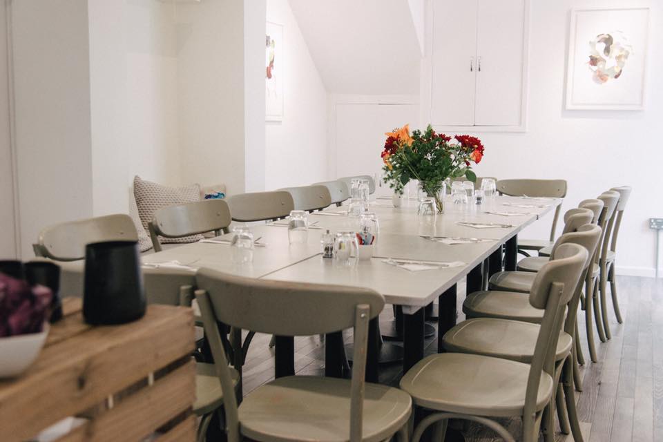 Intimate meeting space with long table, ideal for workshops and corporate events.