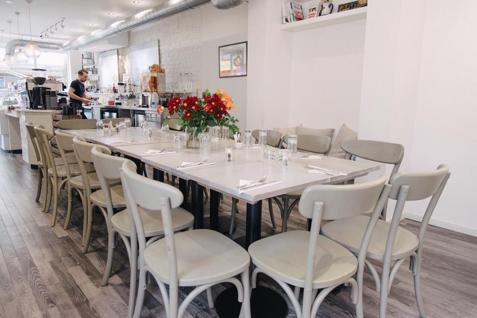 Modern dining table setup with floral centerpiece for meetings in Chelsea Creperie.