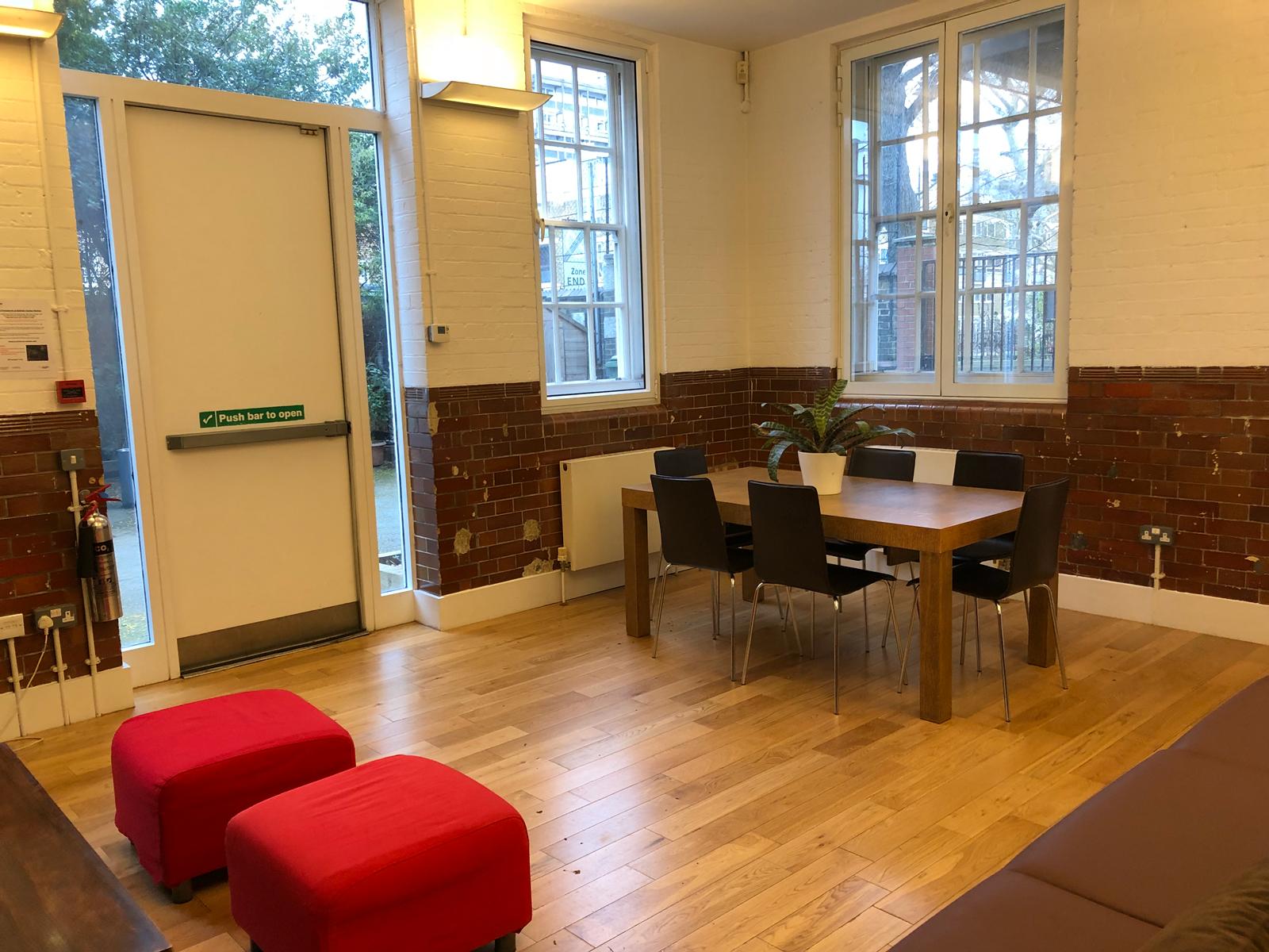 Meeting space with wooden table and black chairs at Siobhan Davies Studios, ideal for networking.