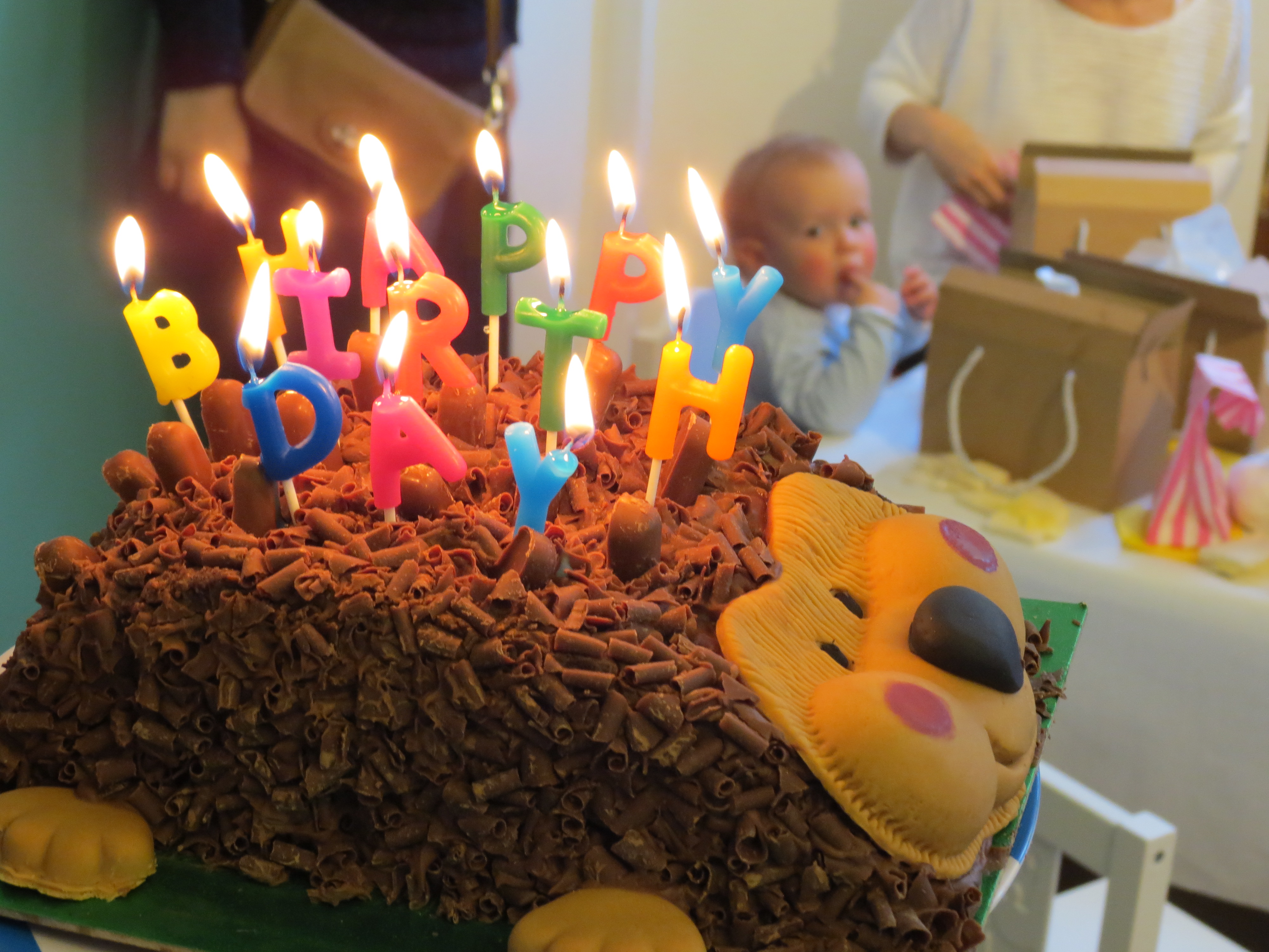 Festive birthday cake with candles in vibrant Siobhan Davies Studios celebration.