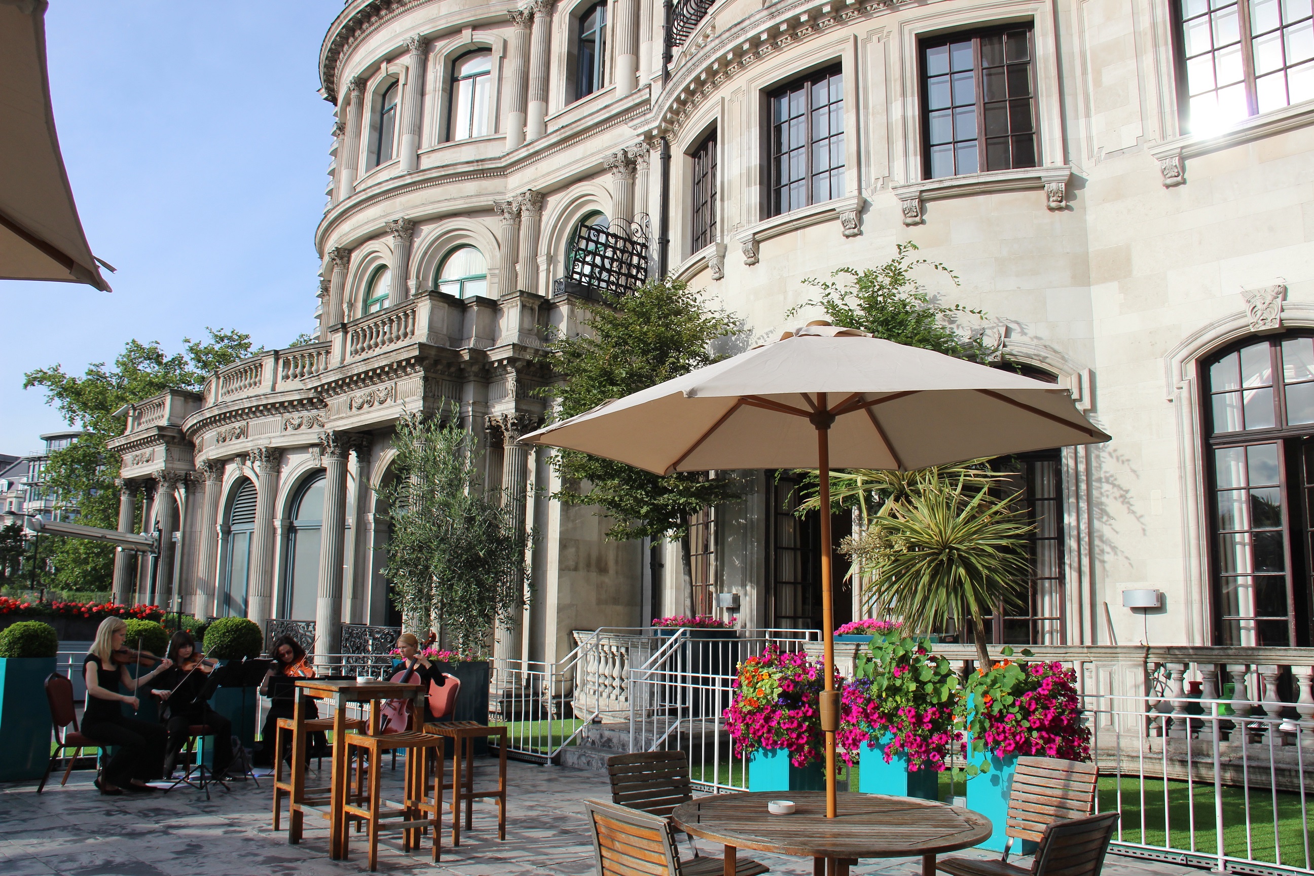 Elegant outdoor wedding venue with historic architecture and vibrant flowers.