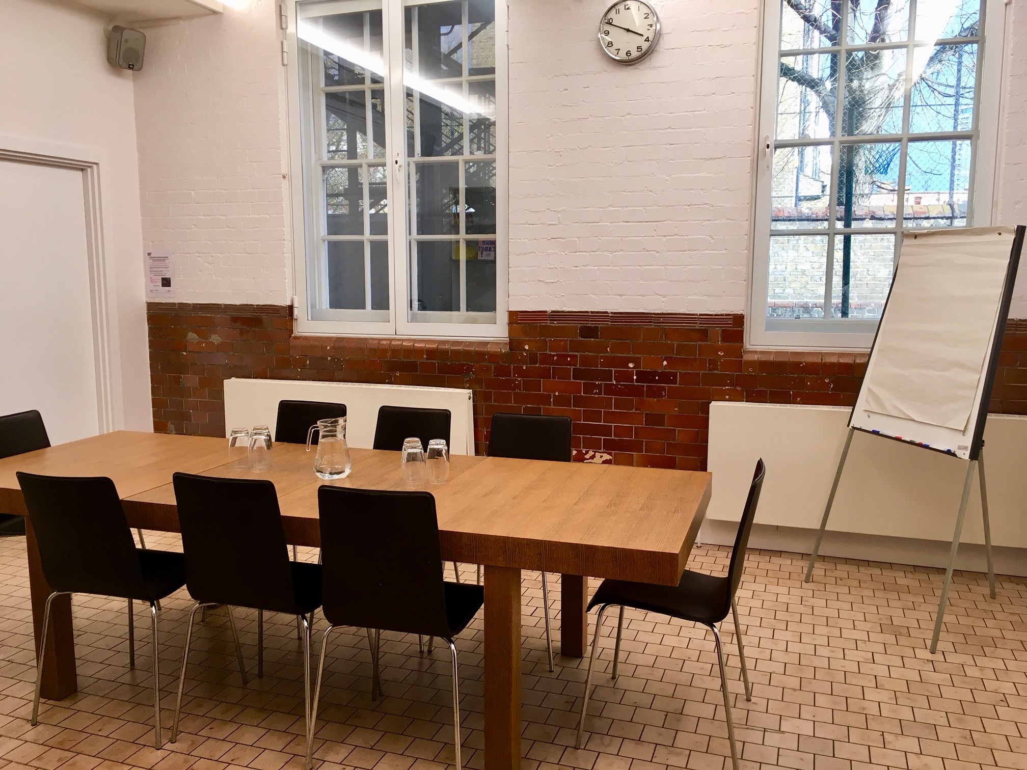 Well-lit meeting room with wooden table and black chairs at Siobhan Davies Studios.