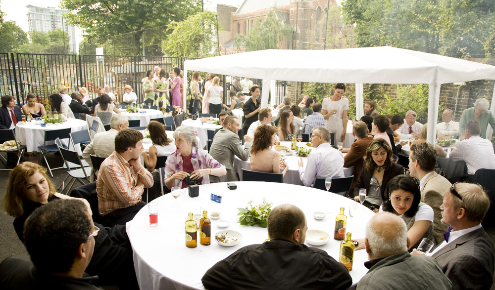 Outdoor wedding setup with round tables in Siobhan Davies Studios for networking and socializing.