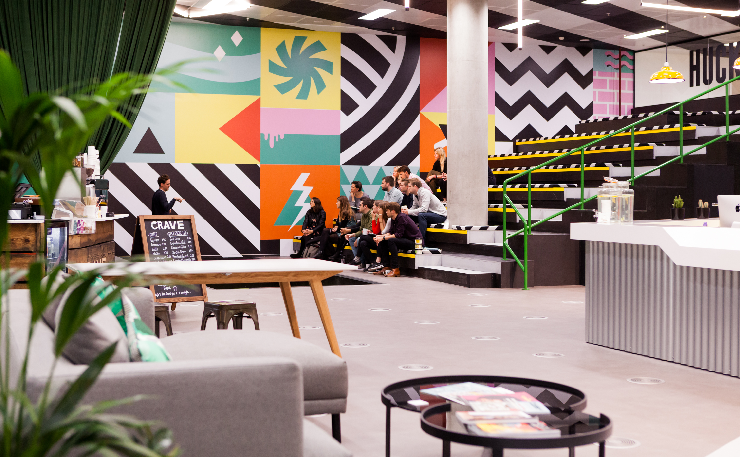 Vibrant Huckletree West auditorium with colorful murals for creative events and workshops.