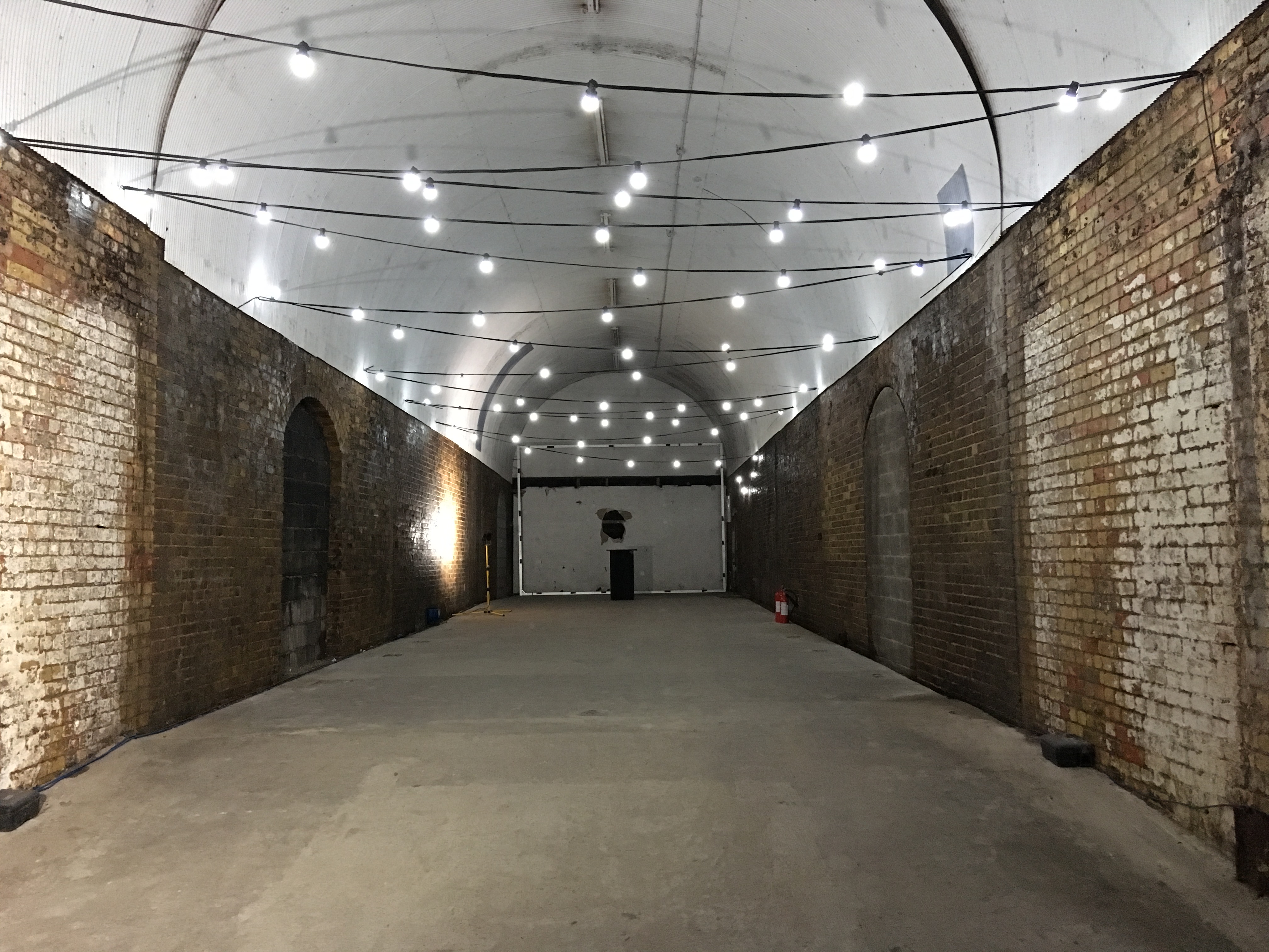 Spacious industrial venue with exposed brick for corporate events and celebrations.