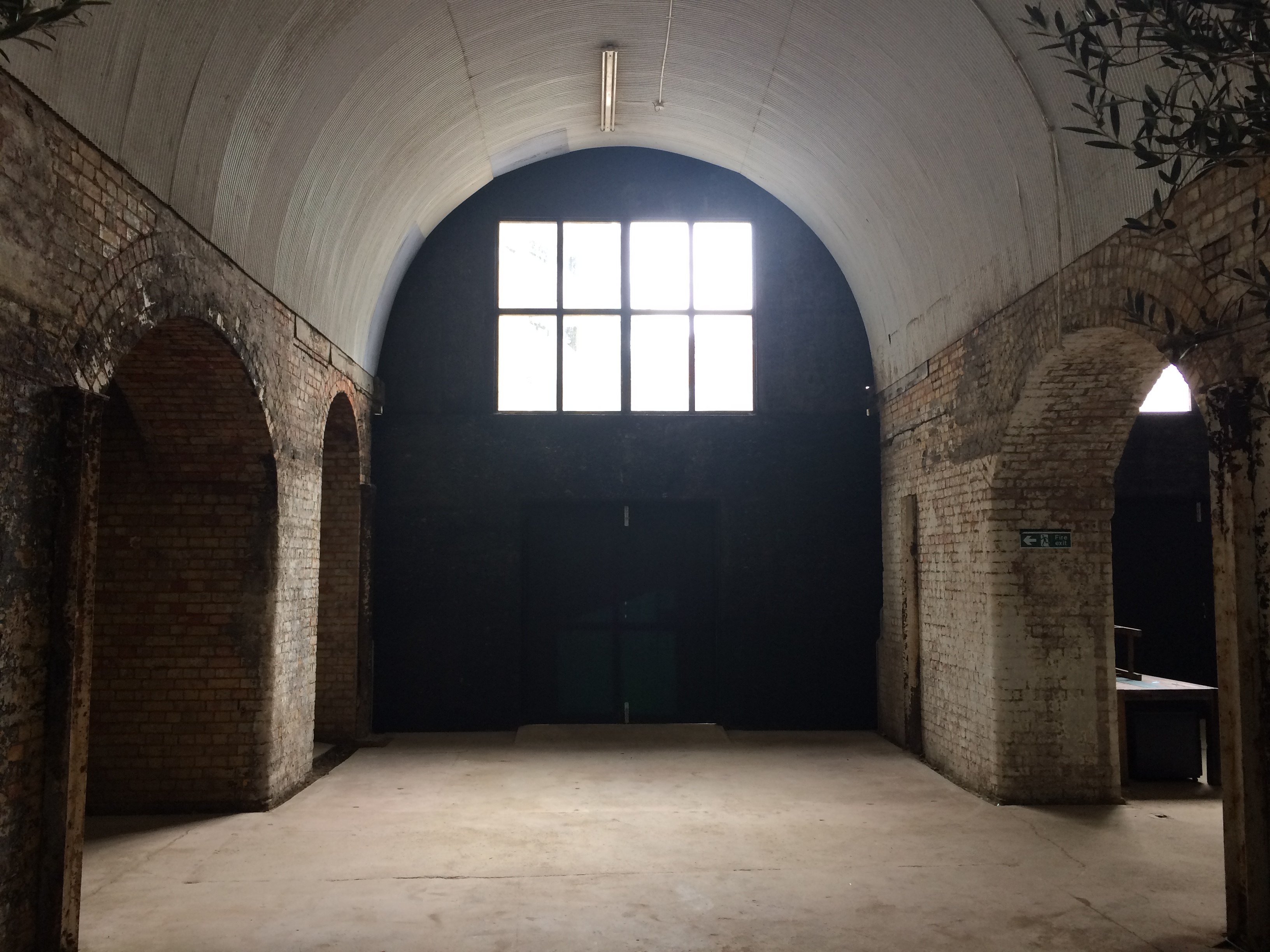Spacious industrial venue with arched ceilings for corporate events and workshops.