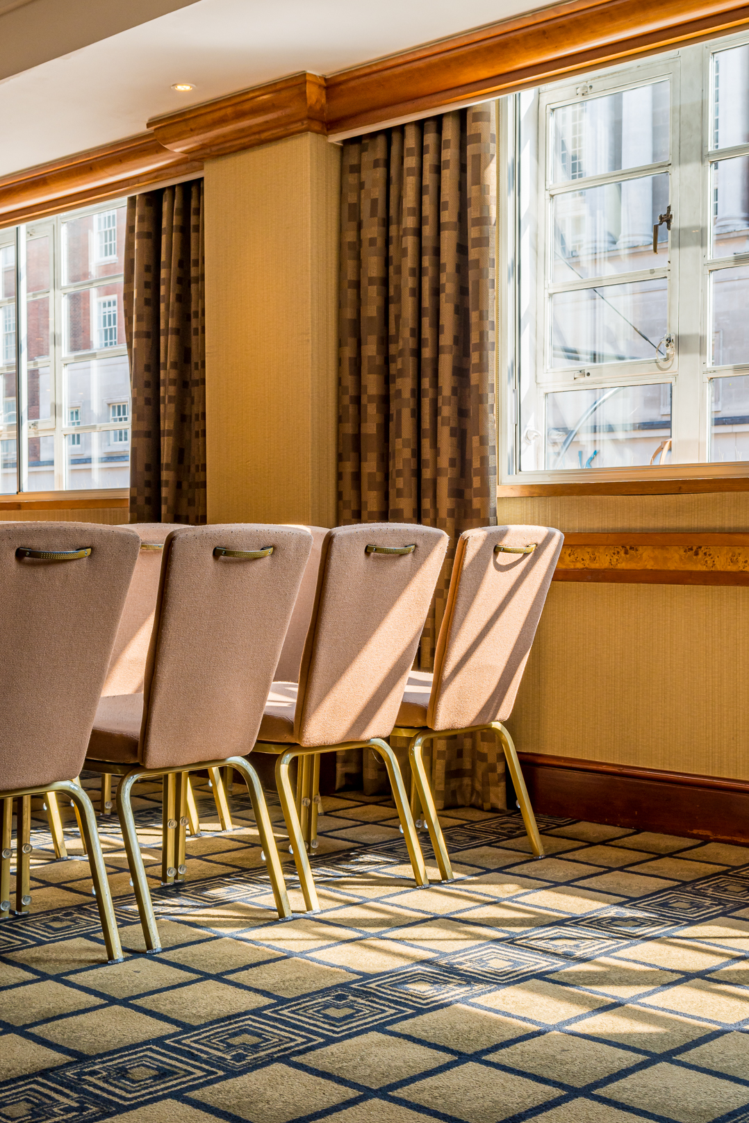 Elegant meeting room with upholstered chairs, ideal for networking and workshops.