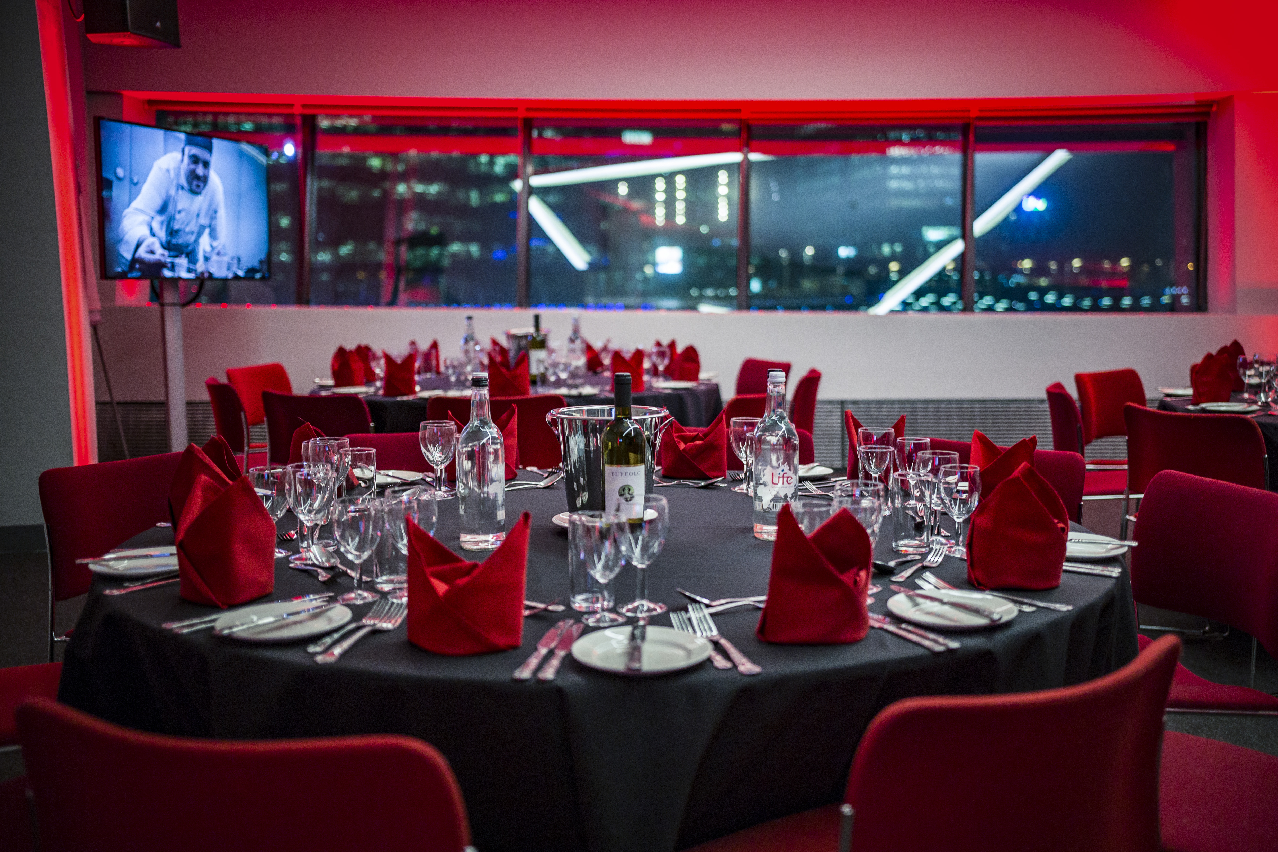Elegant event setup at Imperial War Museum North with black tables and city view.